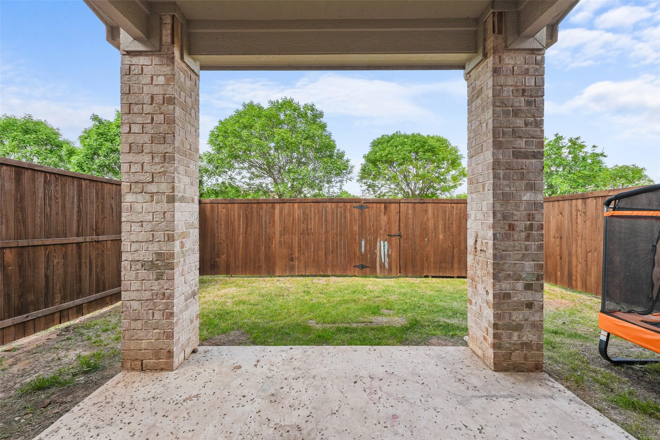 Covered patio featuring a concrete surface and brick columns
