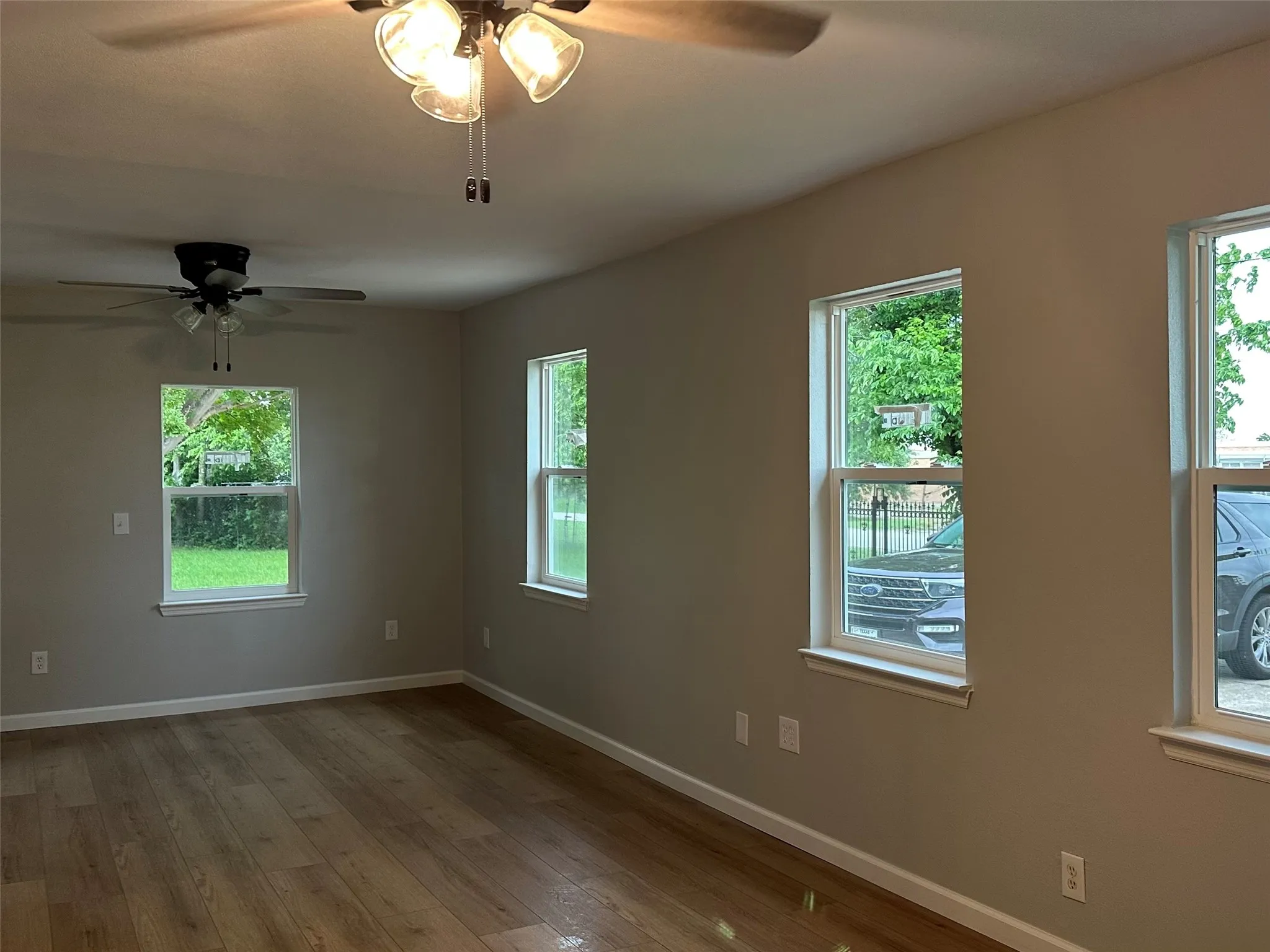 Wood-finish flooring with neutral wall tones and multiple windows