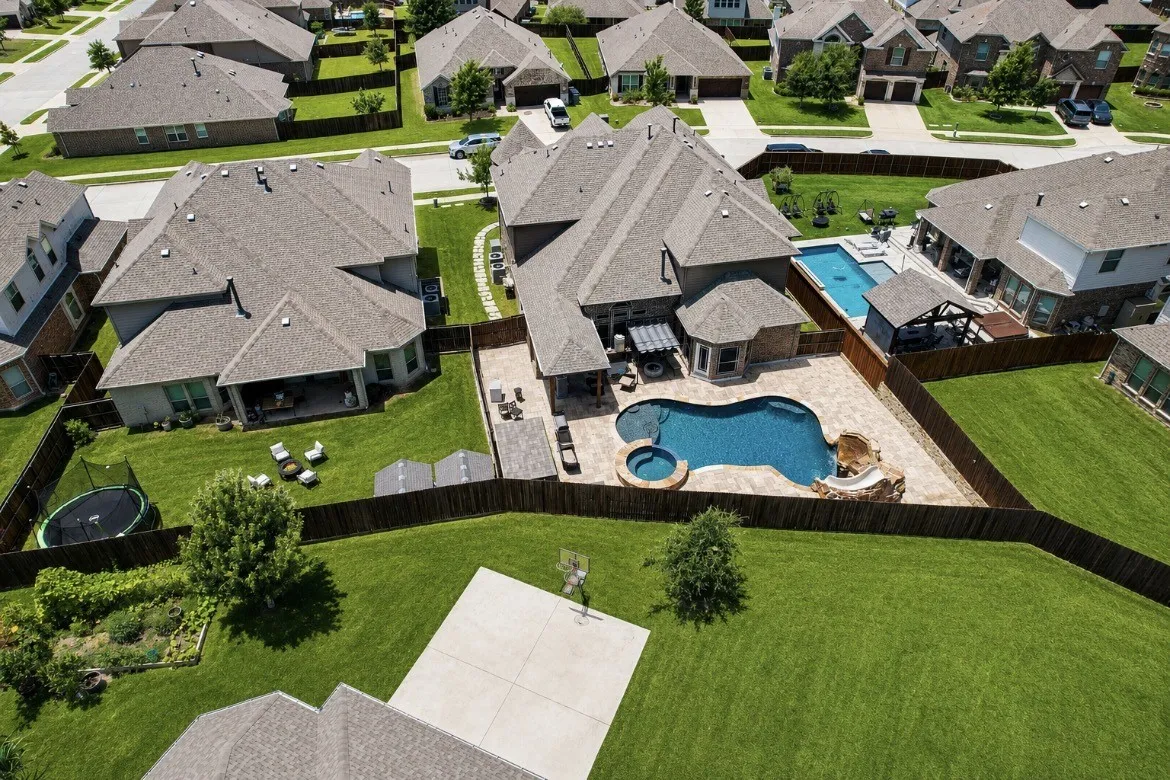 Expansive backyard featuring a freeform swimming pool with integrated spa and rock waterfall