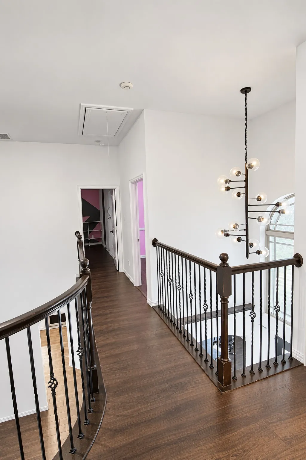 Wood-finish flooring throughout the hallway and open balustrade