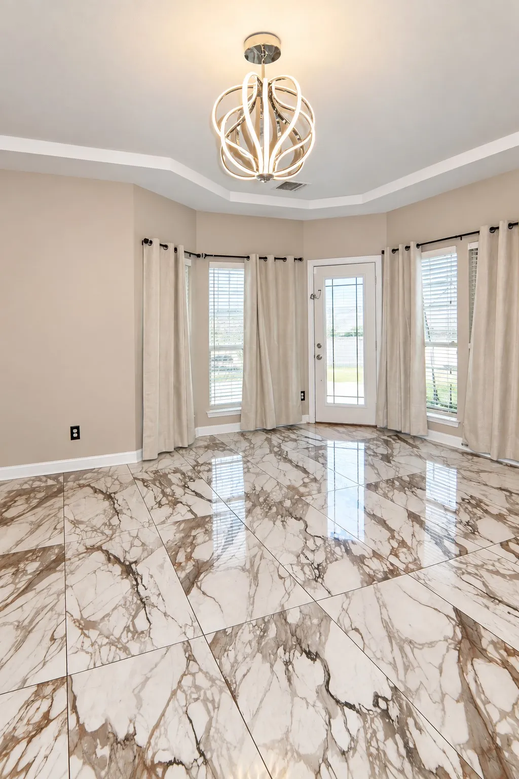 Bay window with multiple windows, crown molding, and a modern ceiling light fixture