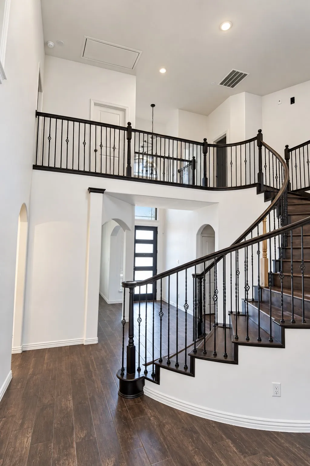 Grand foyer featuring a spiral staircase with dark wood-finish treads and wrought iron balusters
