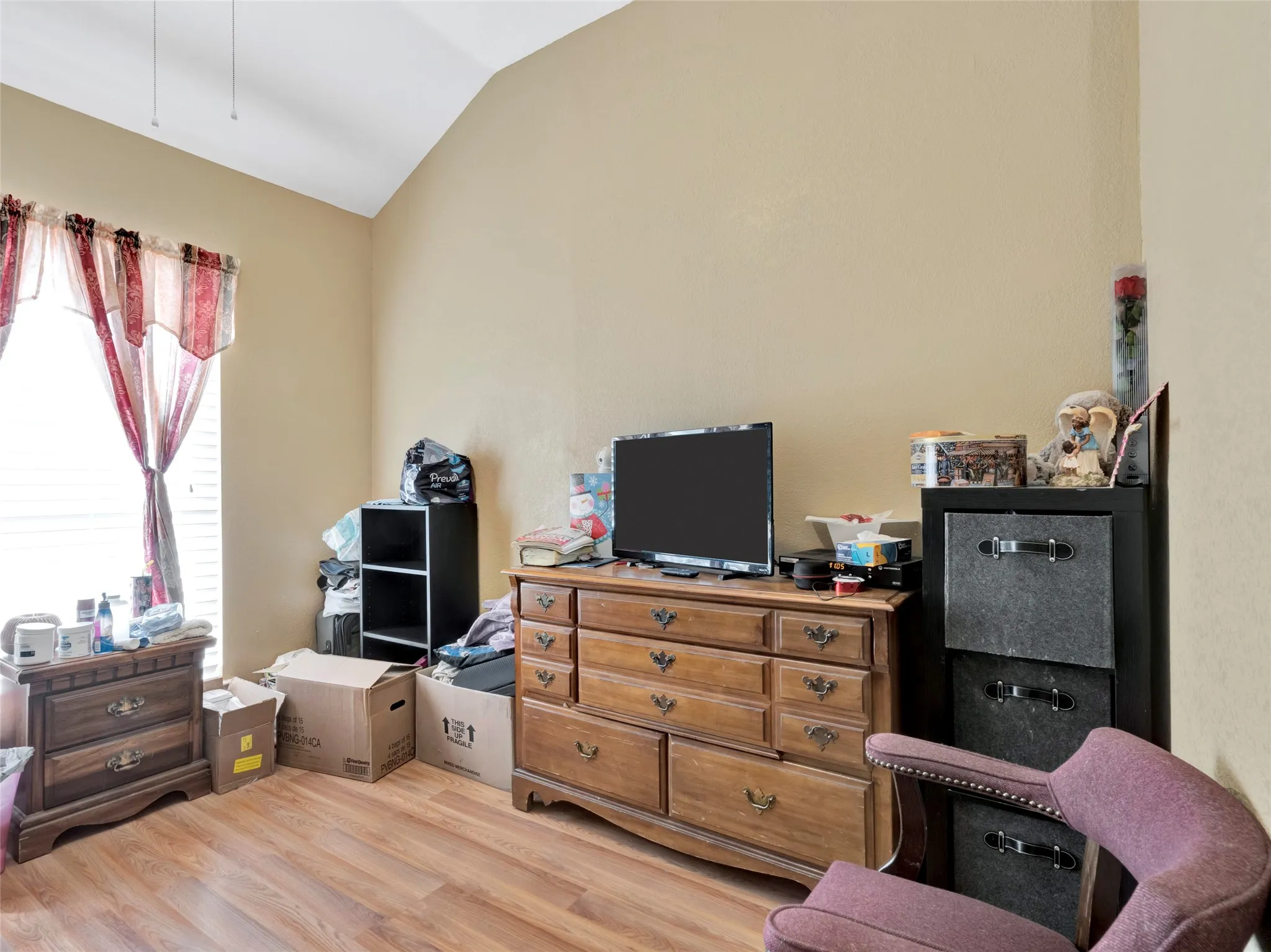 Vaulted ceiling, wood-finish flooring, and natural light