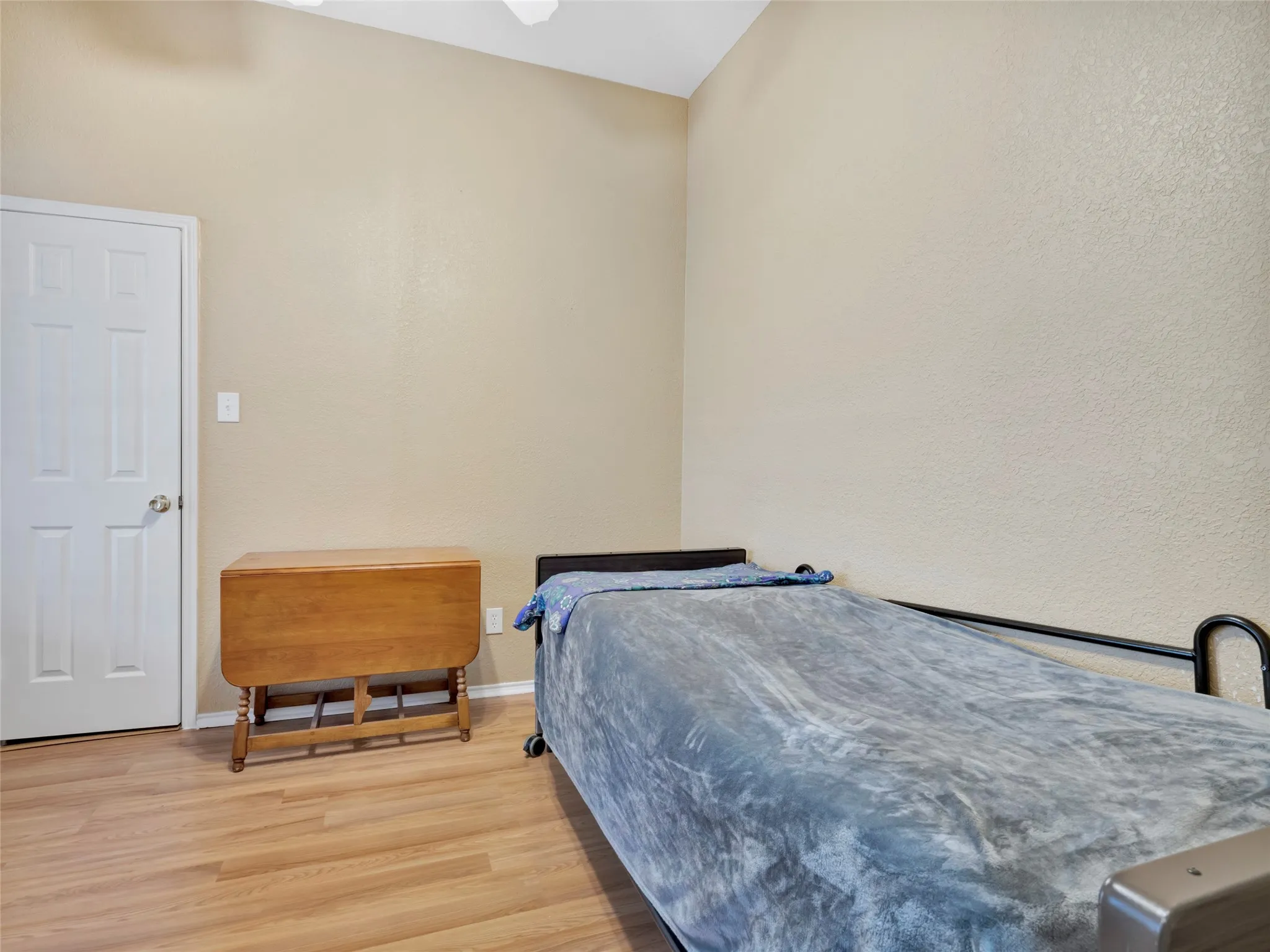 Wood-finish flooring with a neutral wall tone and vaulted ceiling