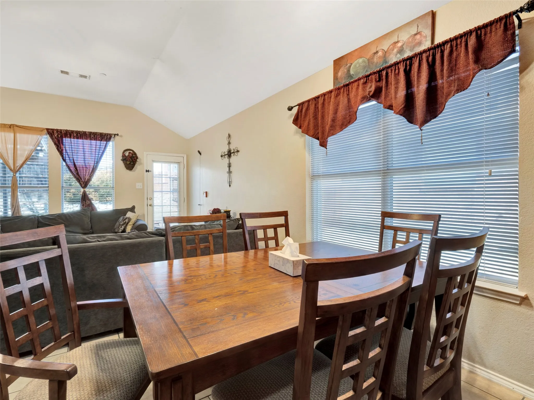 Vaulted ceiling, multiple windows with blinds, light-toned wall paint
