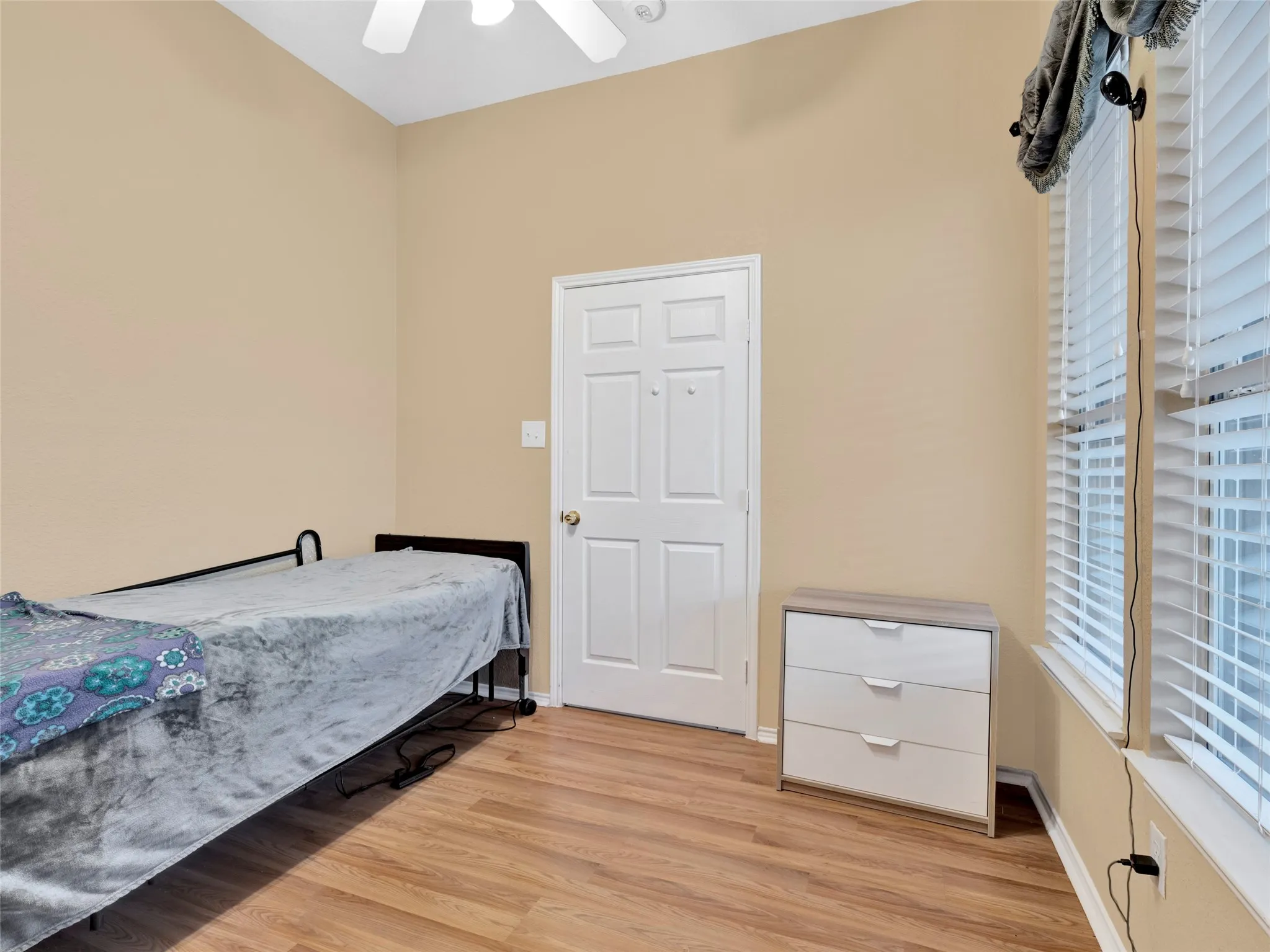 Vaulted ceiling with a ceiling fan, wood-finish flooring, and white window blinds