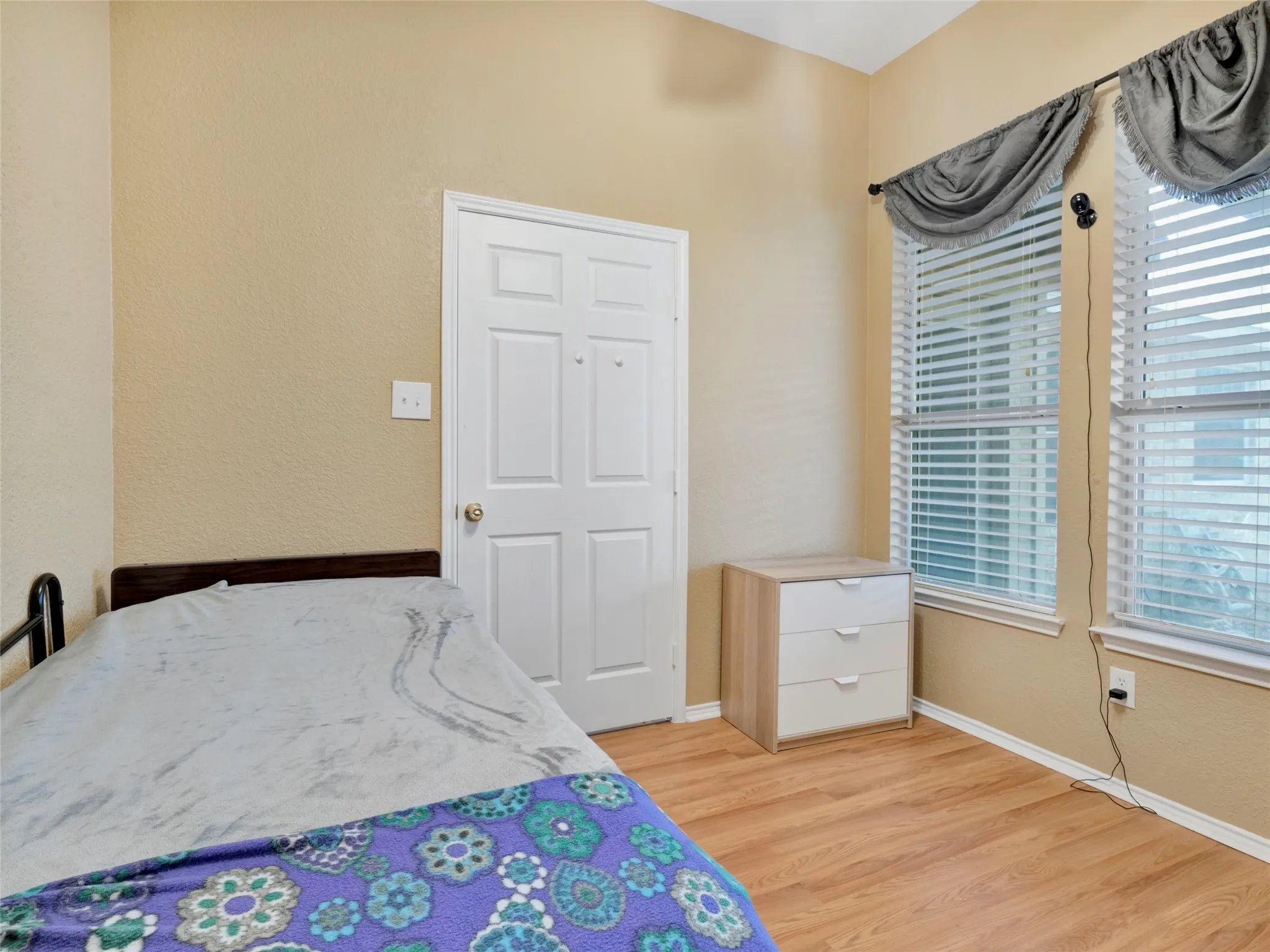 Wood-finish flooring, multiple windows with blinds, recessed lighting, and an overhead light fixture