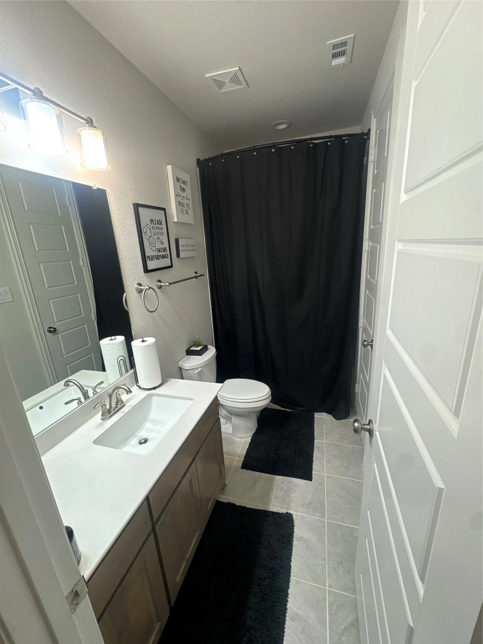 Bathroom featuring a vanity with an integrated sink, a built-in mirror, and brushed nickel fixtures