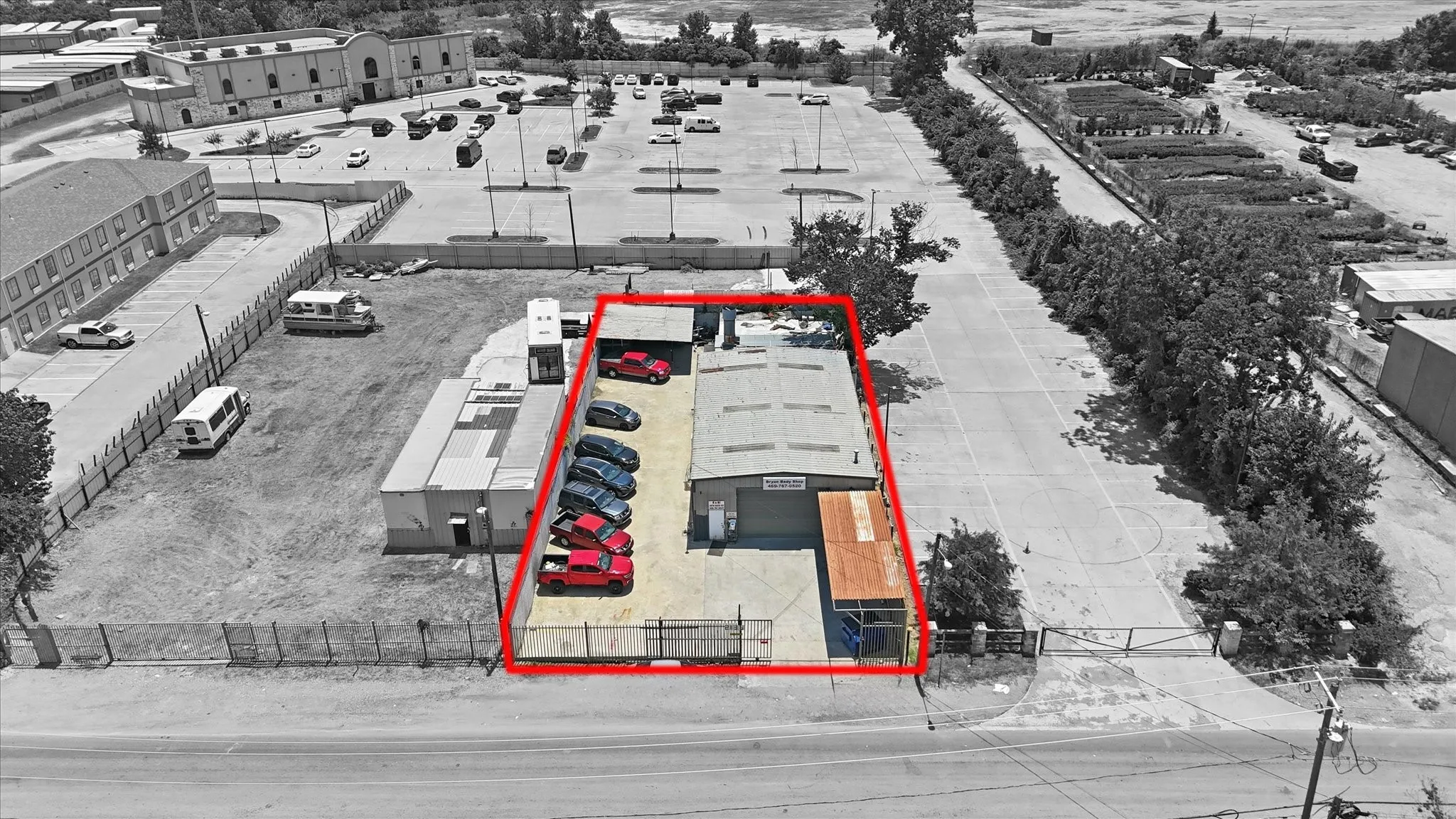 Commercial property featuring a primary building with a metal roof and an attached covered loading area