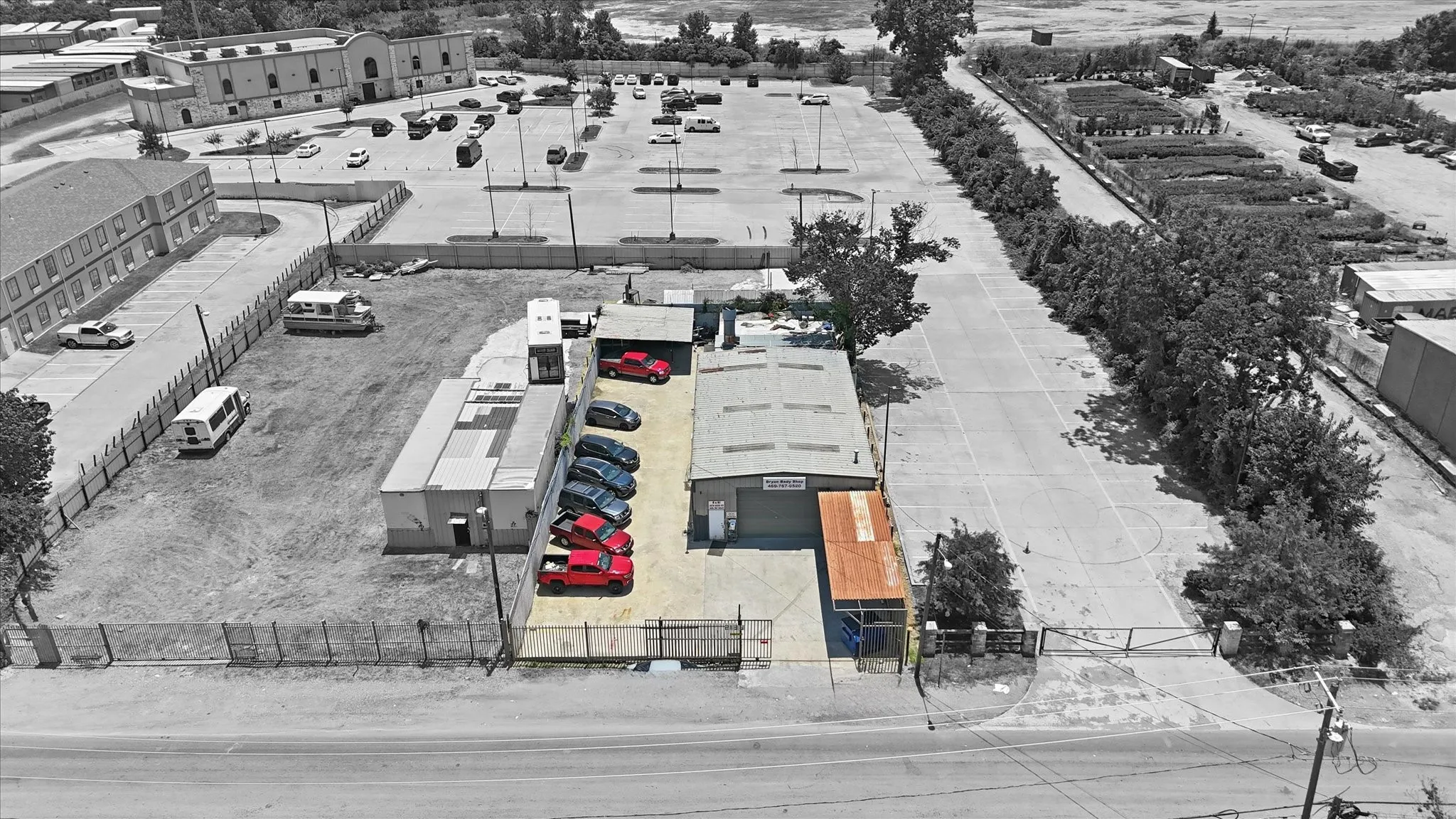 Commercial property featuring a primary building with an attached carport, an adjacent paved parking area, and two additional modular structures