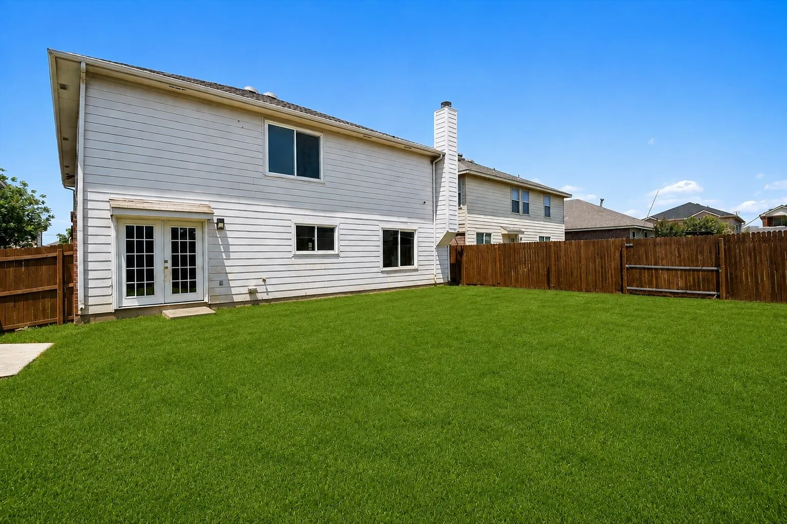 Beautiful back exterior featuring a peaceful backyard. Grass and fence has been virtually enhanced.