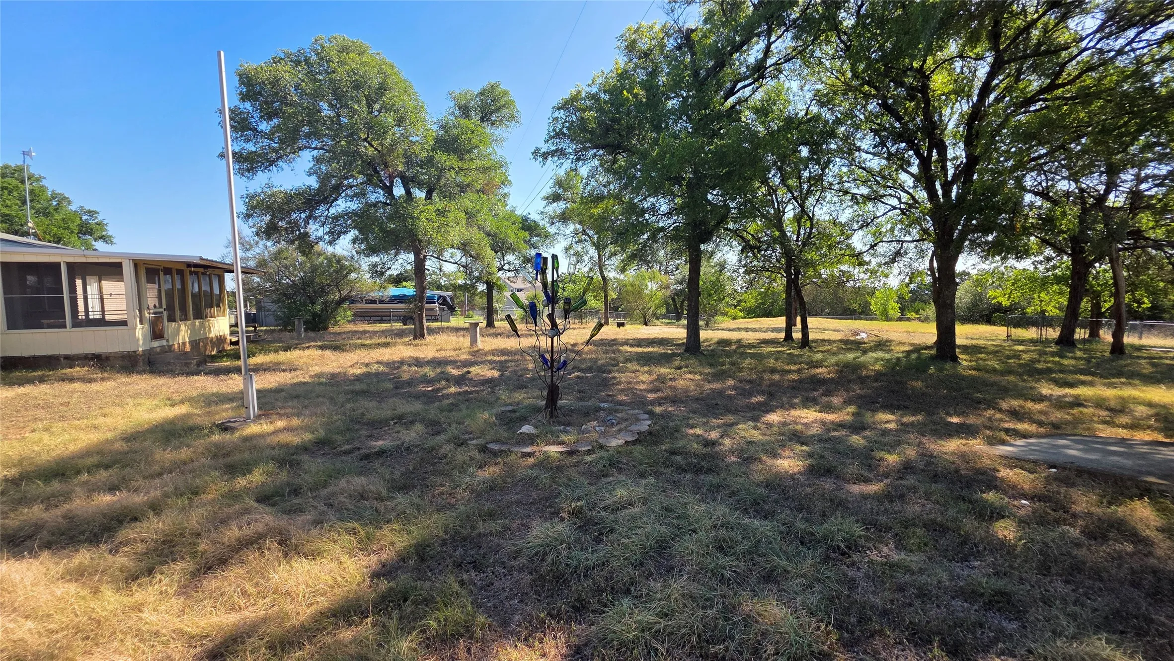 Expansive outdoor space featuring mature trees and a large, open lot