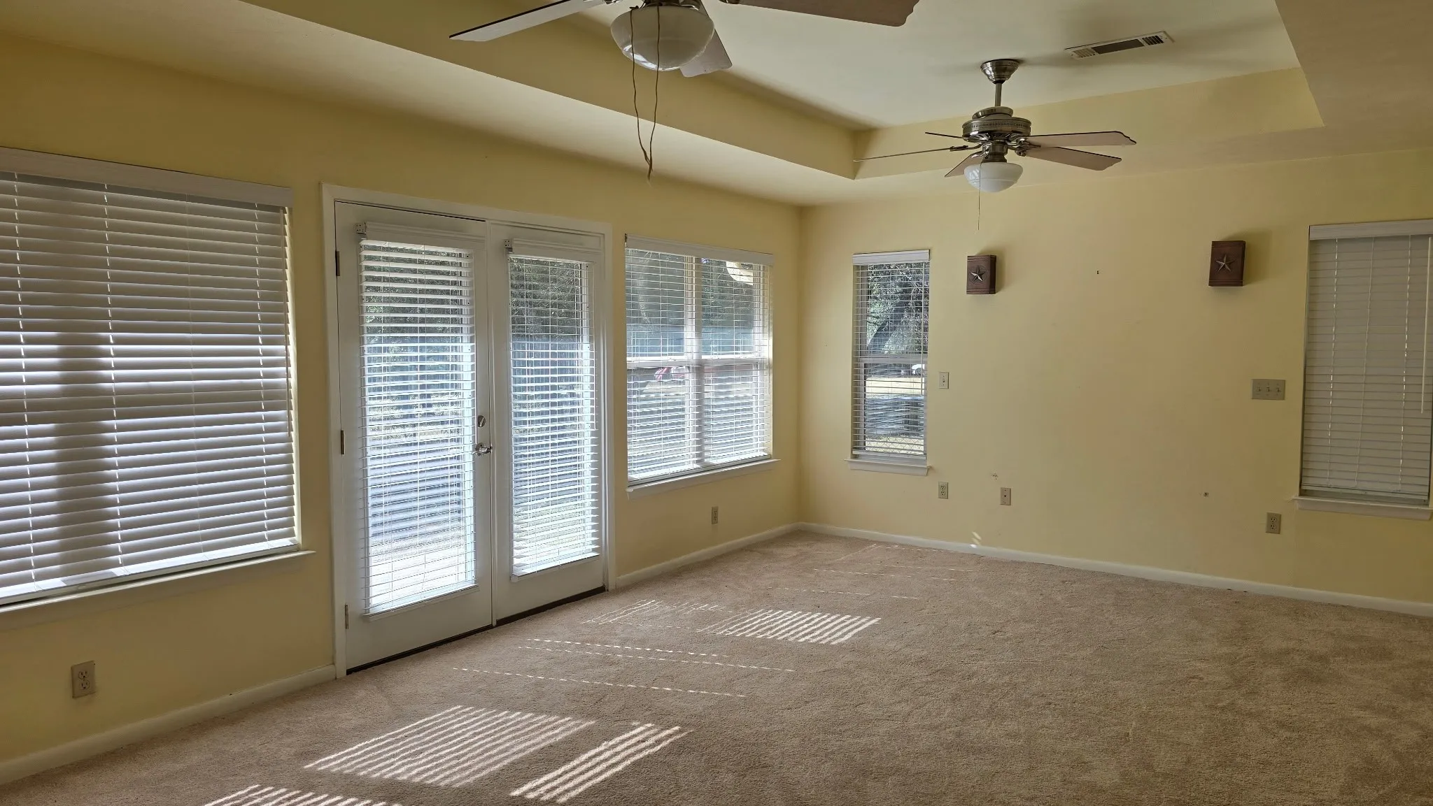 Spacious room with tray ceiling and light beige carpeting