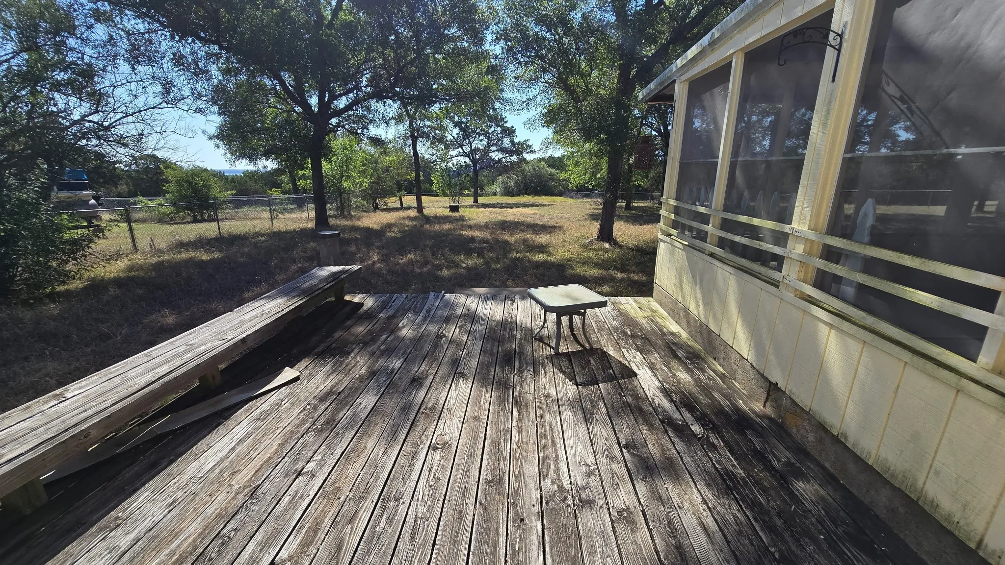 Expansive exterior wood deck with a built-in bench, offering ample outdoor space