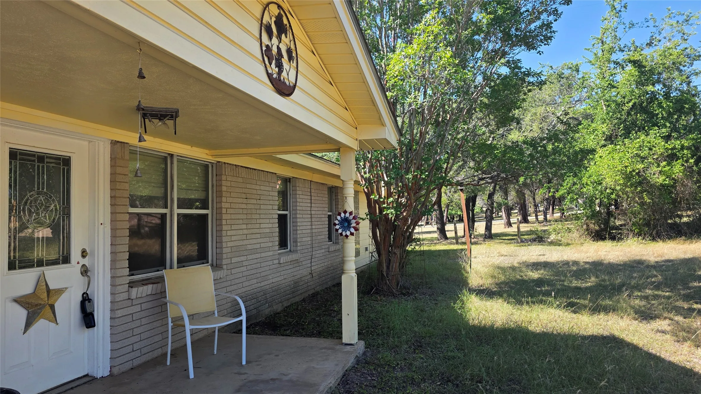 Covered front porch featuring a decorative glass-paneled entry door