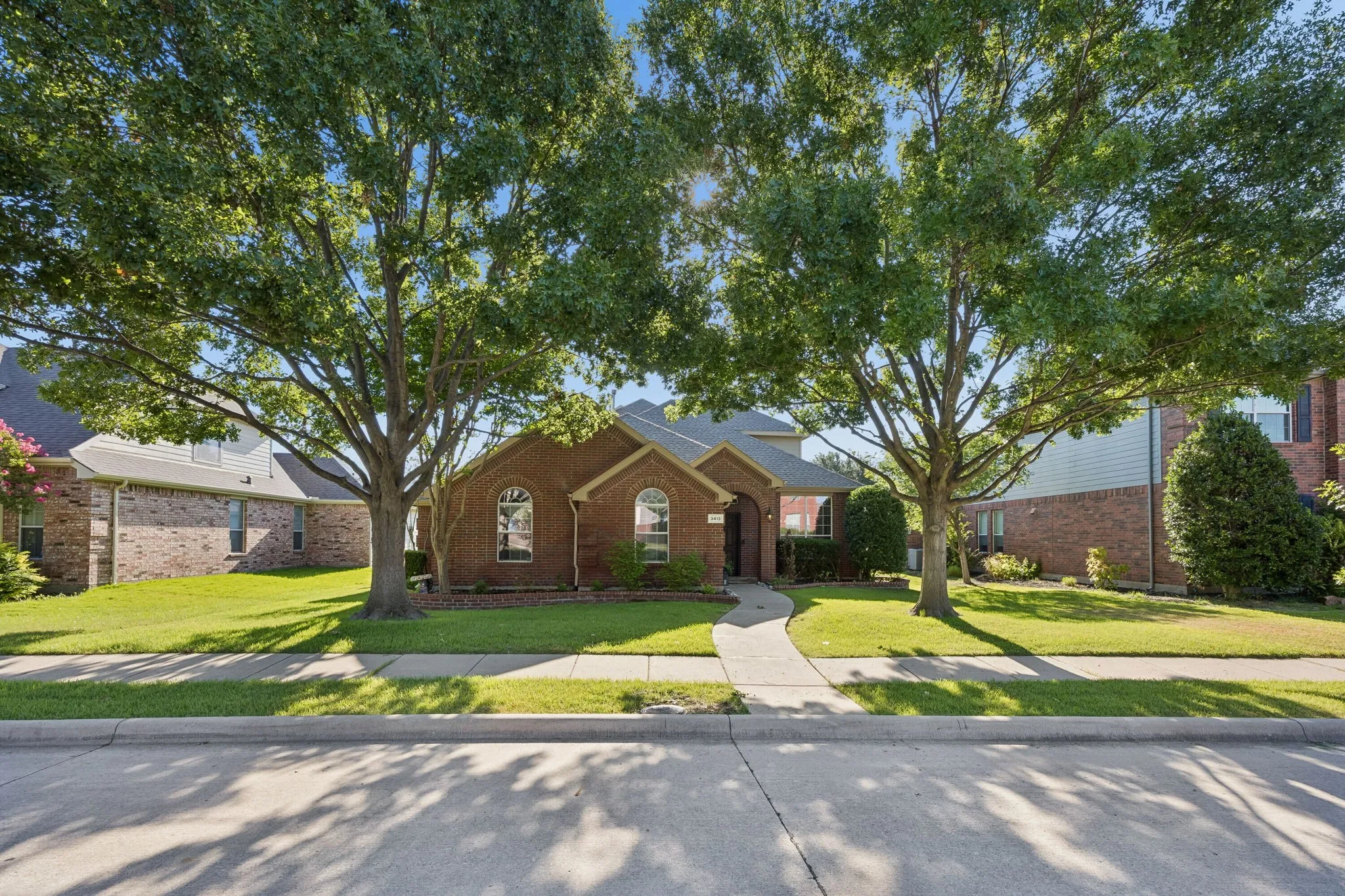 Mature landscaping and a rear-entry garage preserve the home’s attractive front elevation.
