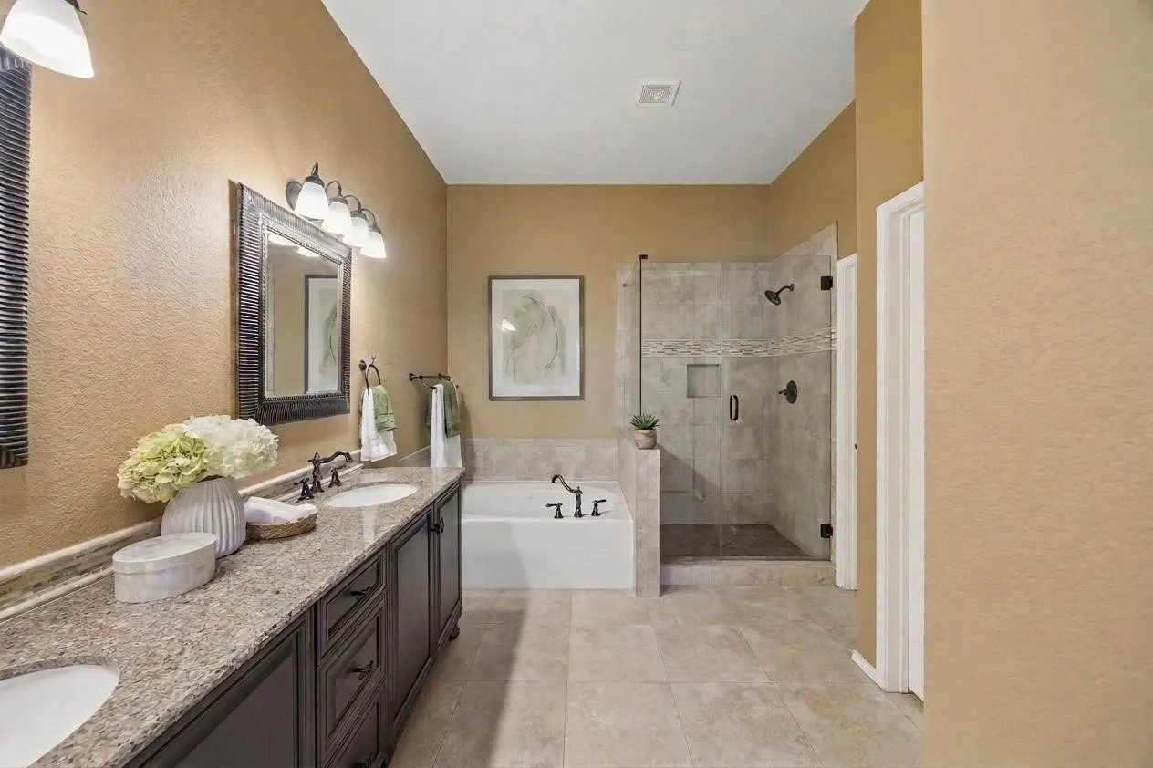 A glass-enclosed shower, soaking tub and updated tile complete the primary bath.
