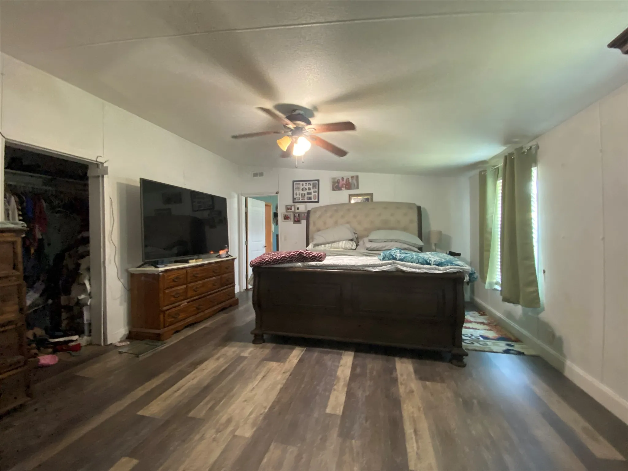 Bedroom with dark wood-style flooring and ceiling fan