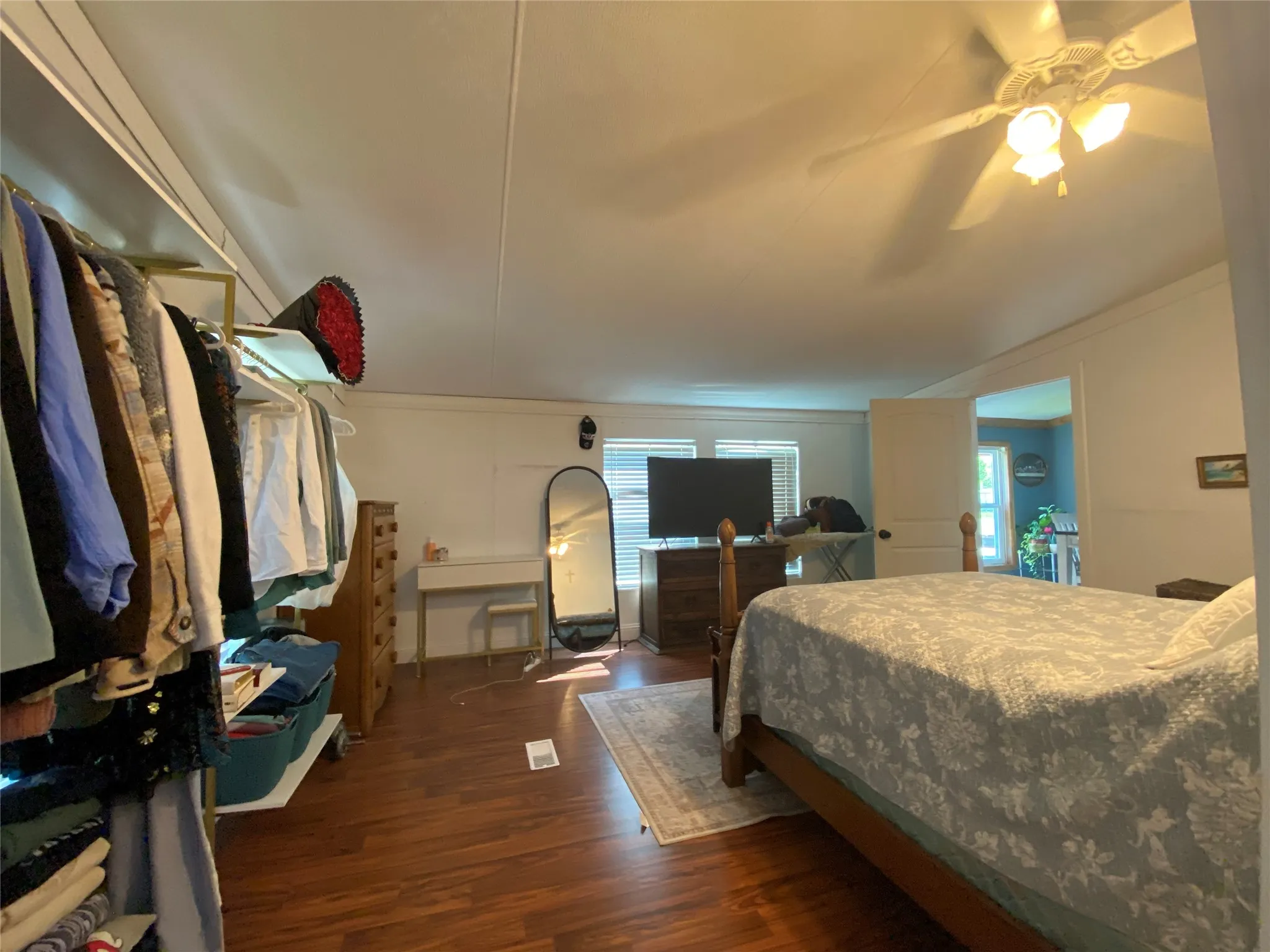 Bedroom with dark wood-style flooring, a ceiling fan, and ornamental molding