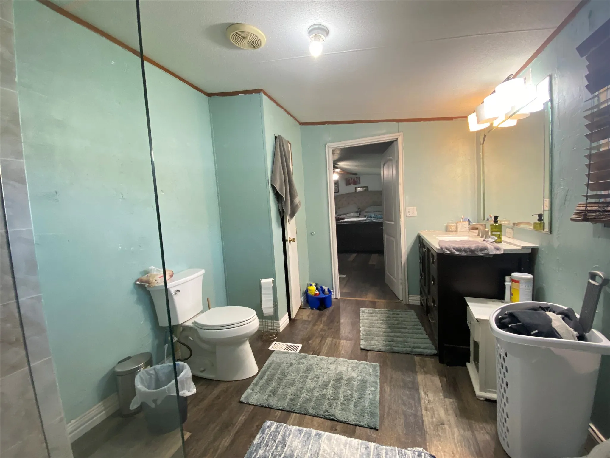 Bathroom featuring crown molding, dark wood-style flooring, and vanity