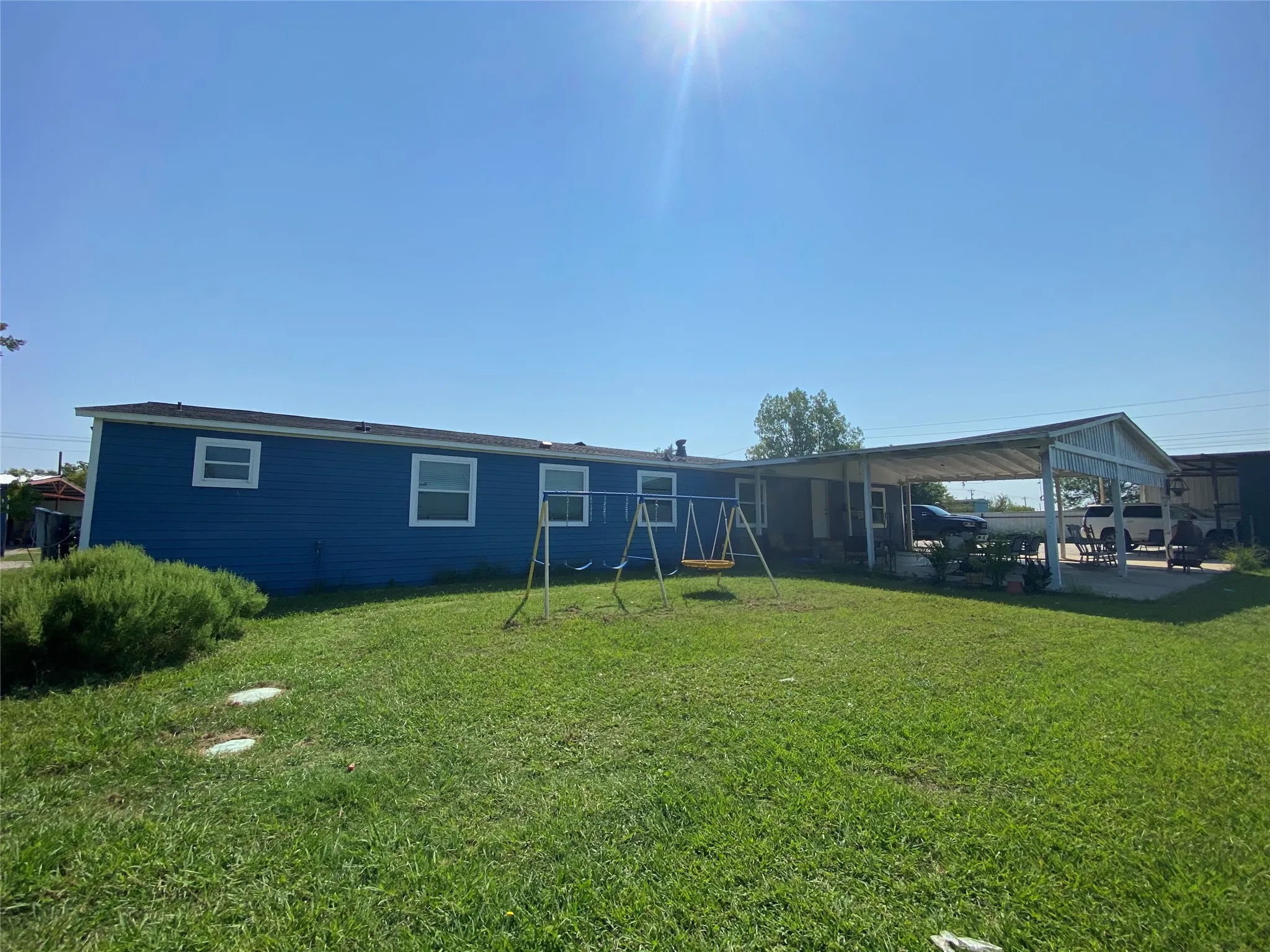 Rear view of property with a patio and a yard