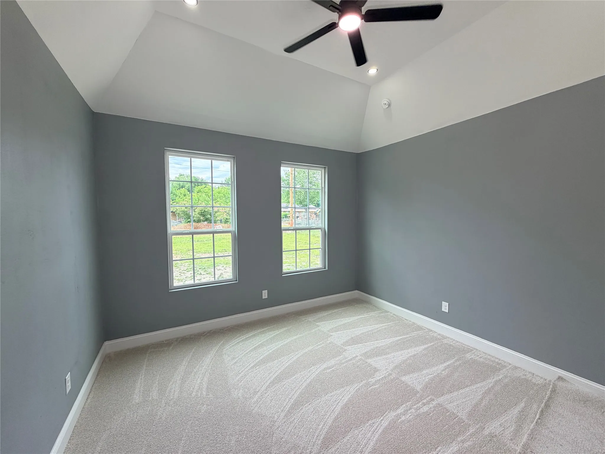 Room featuring a vaulted ceiling with recessed lighting and a ceiling fan
