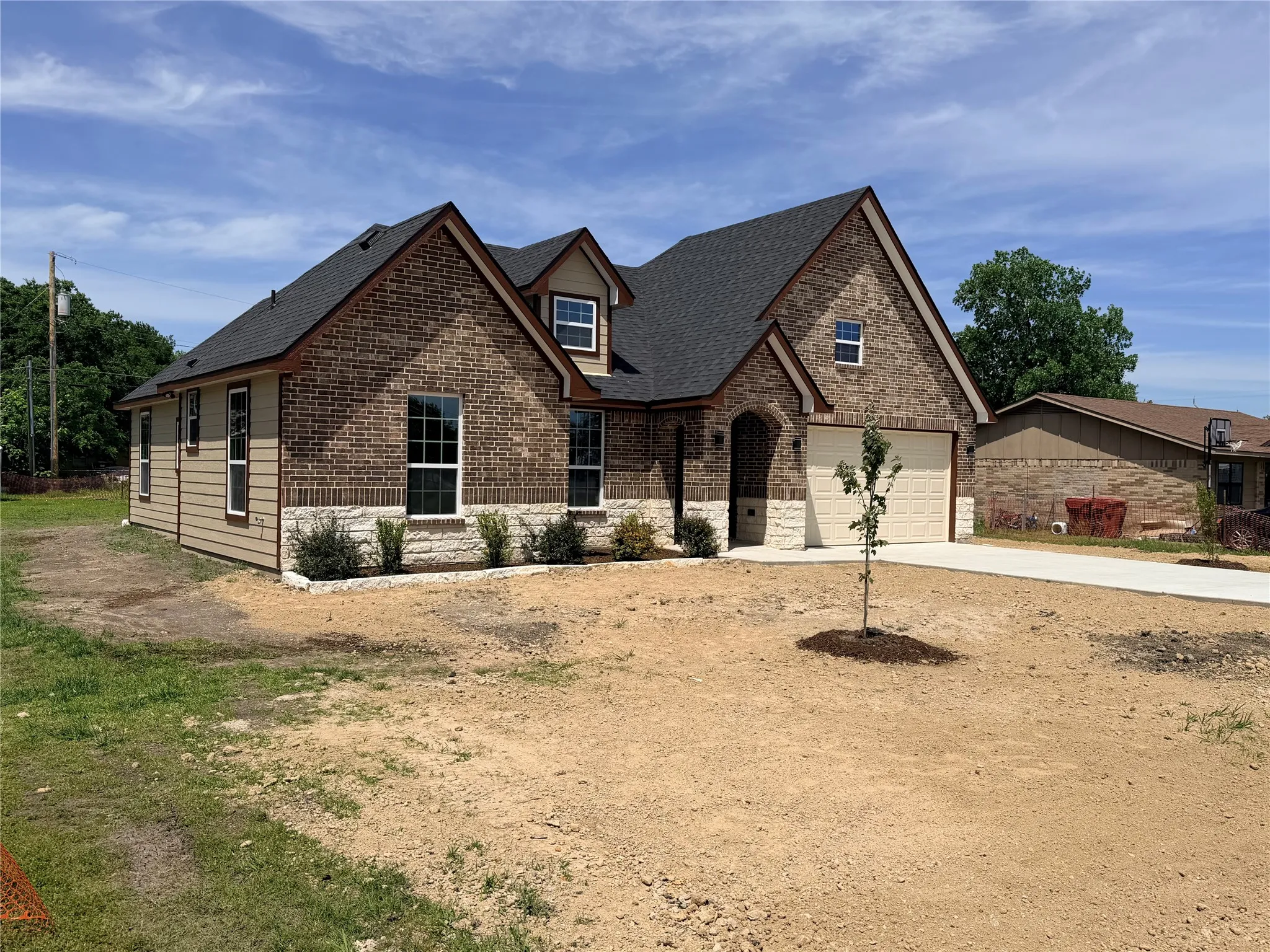 Brick and stone veneer exterior with tan siding accents