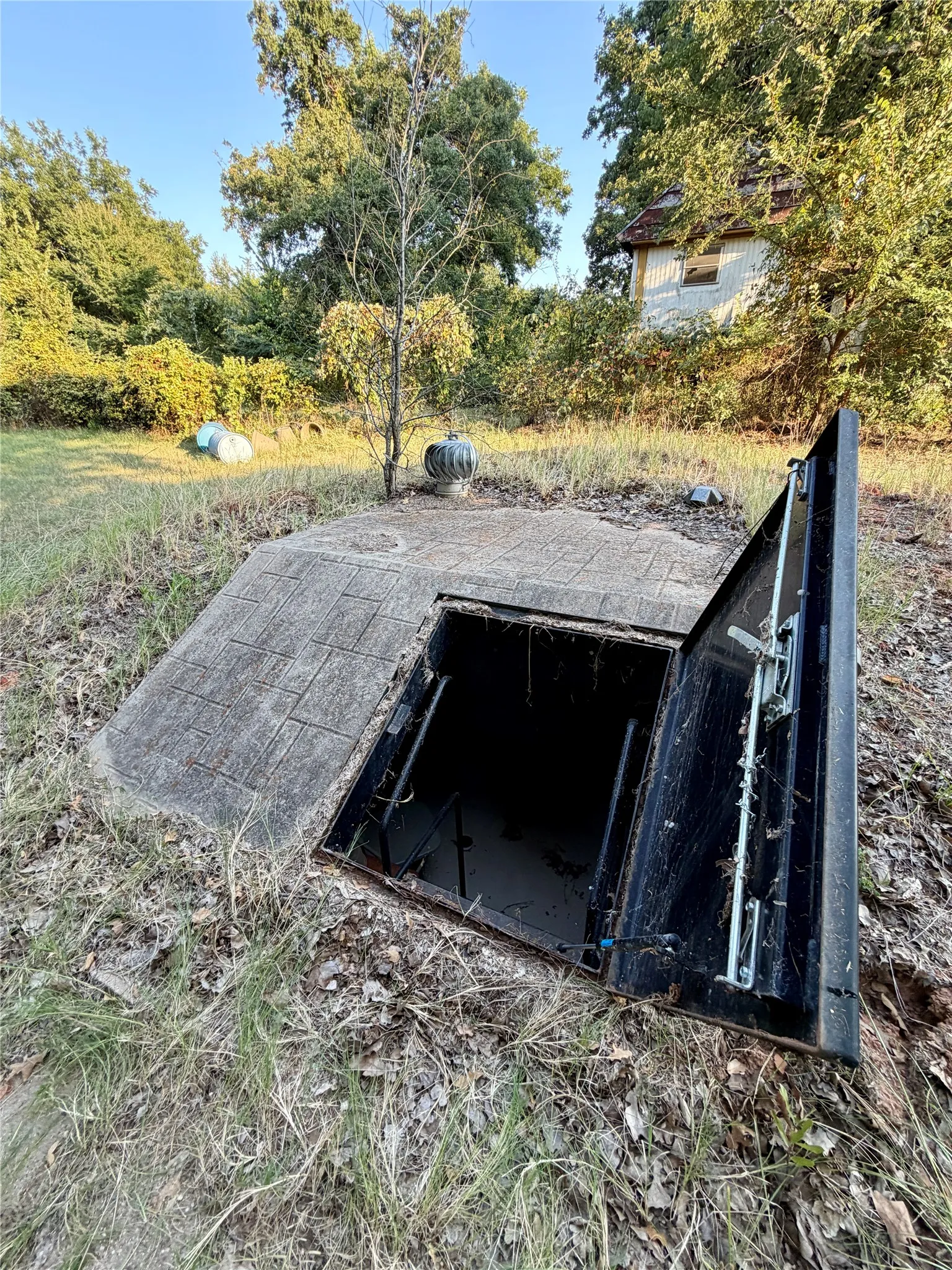 Subterranean access point featuring a heavy-duty metal door and concrete surround
