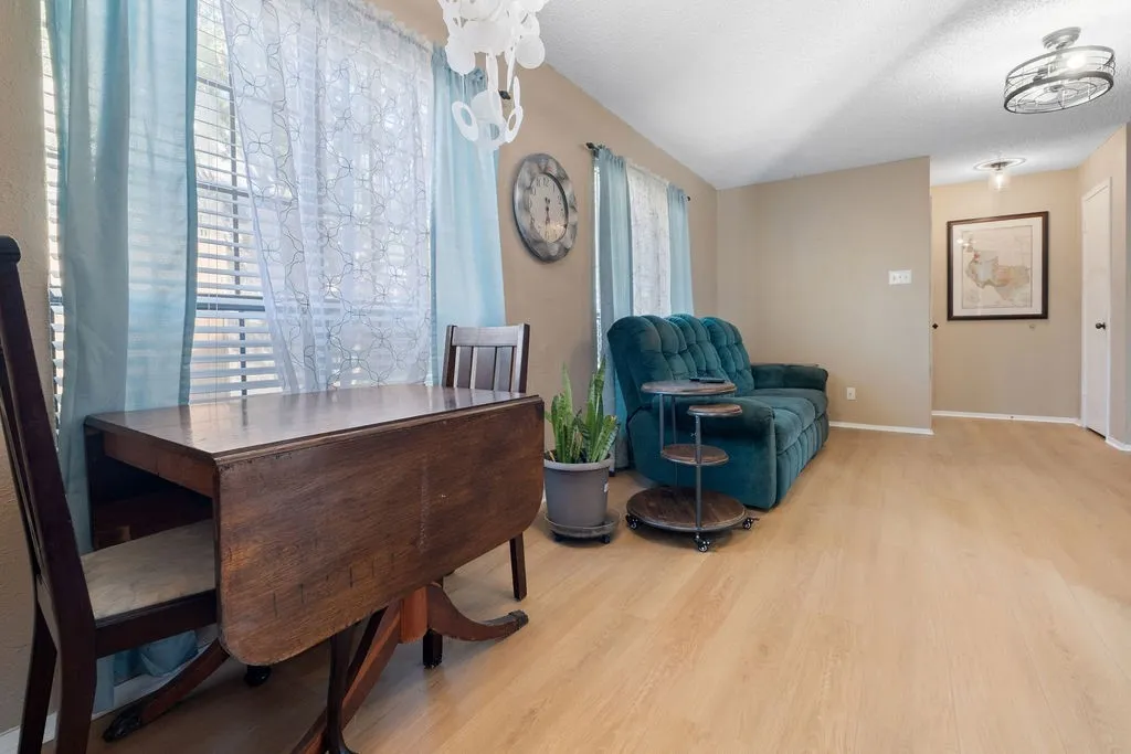 Living area featuring light wood-finish flooring, neutral wall paint, and ceiling-mounted light fixtures