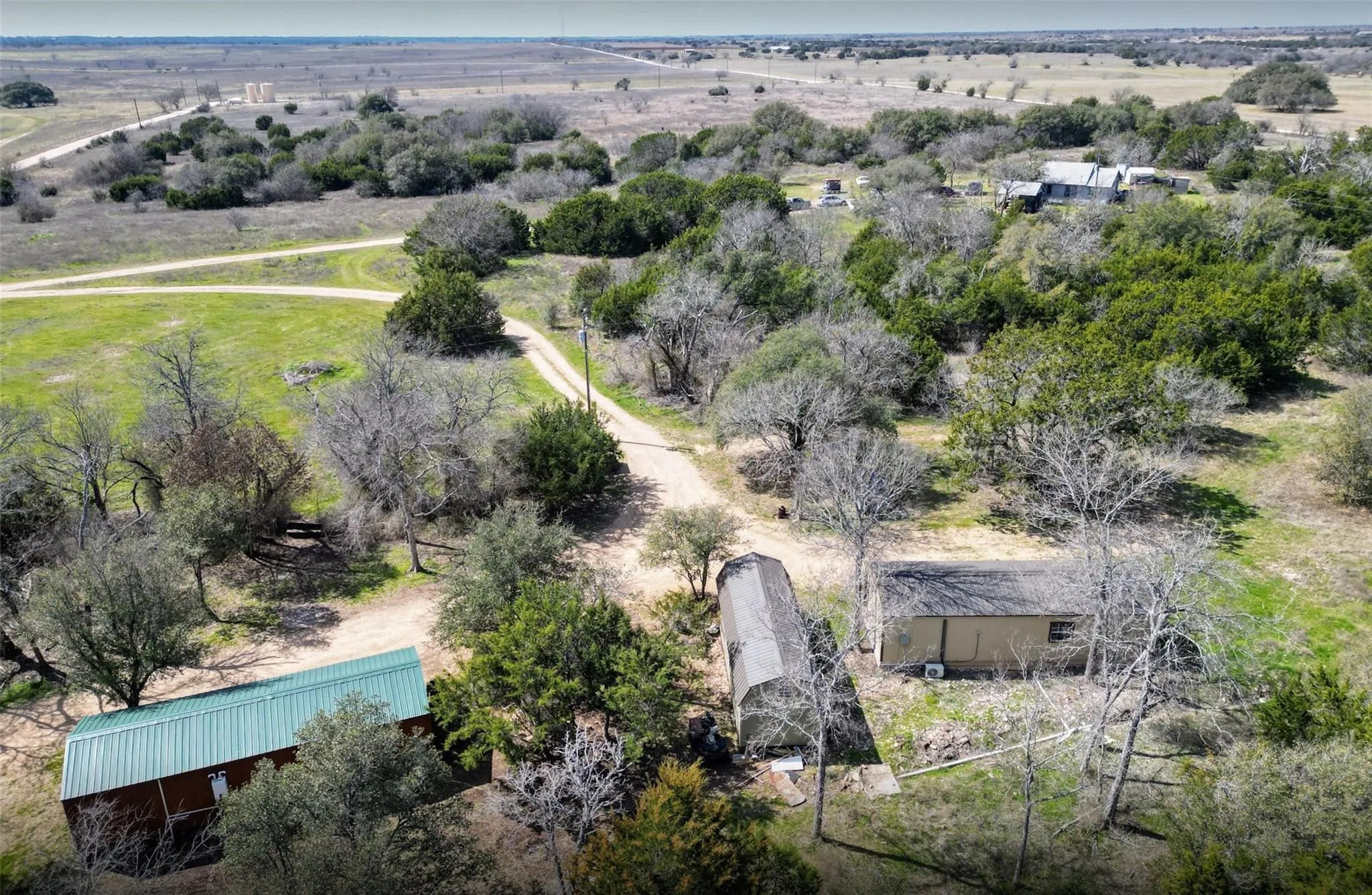 Expansive rural landscape featuring a structure with a metal roof.