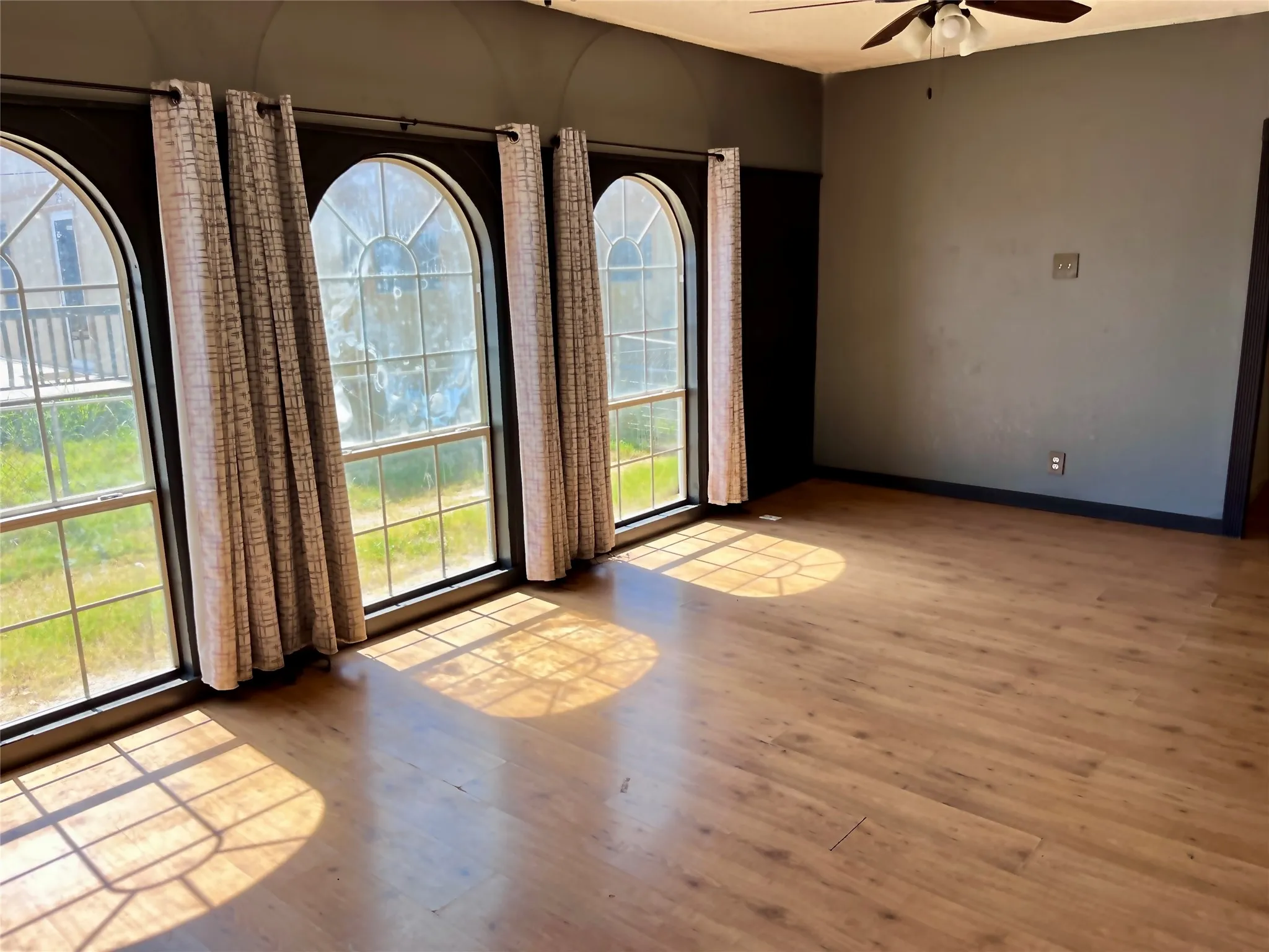 Expansive family room filled with natural light from distinctive arched windows, creating the perfect space for gathering with family and friends.