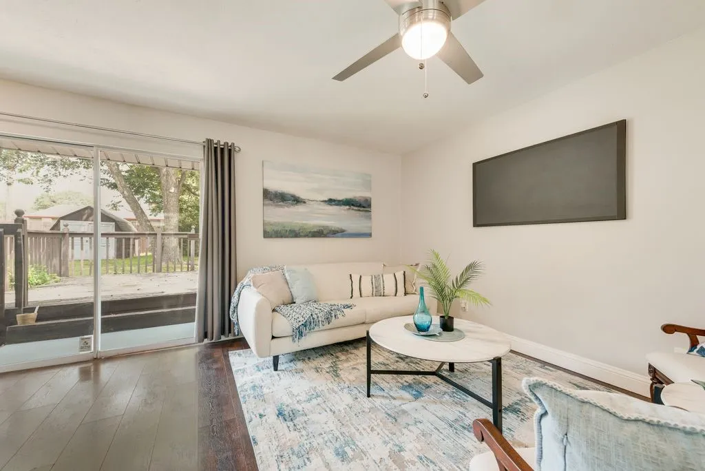 Spacious interior featuring dark wood-finish flooring and a ceiling fan with integrated lighting