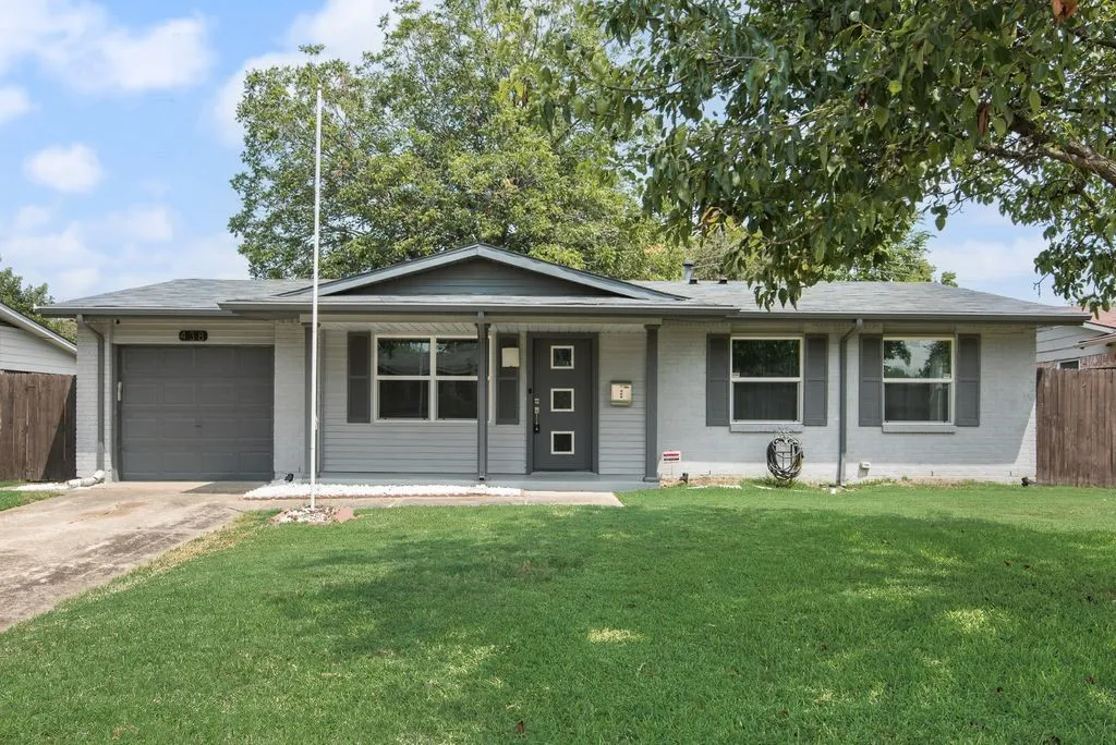 Contemporary ranch-style home featuring a light gray brick and siding exterior