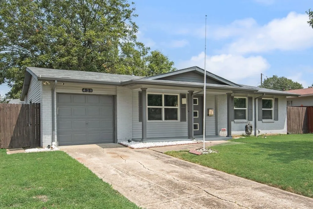 Modern single-story home featuring a clean-lined exterior with gray fiber cement siding, a covered front porch with large picture windows, and an attached two-car garage