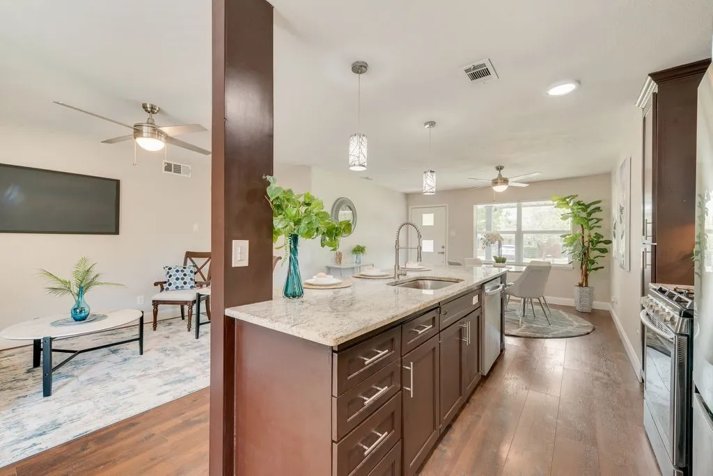 Kitchen island with granite-style countertop and integrated sink, featuring wood-finish cabinetry