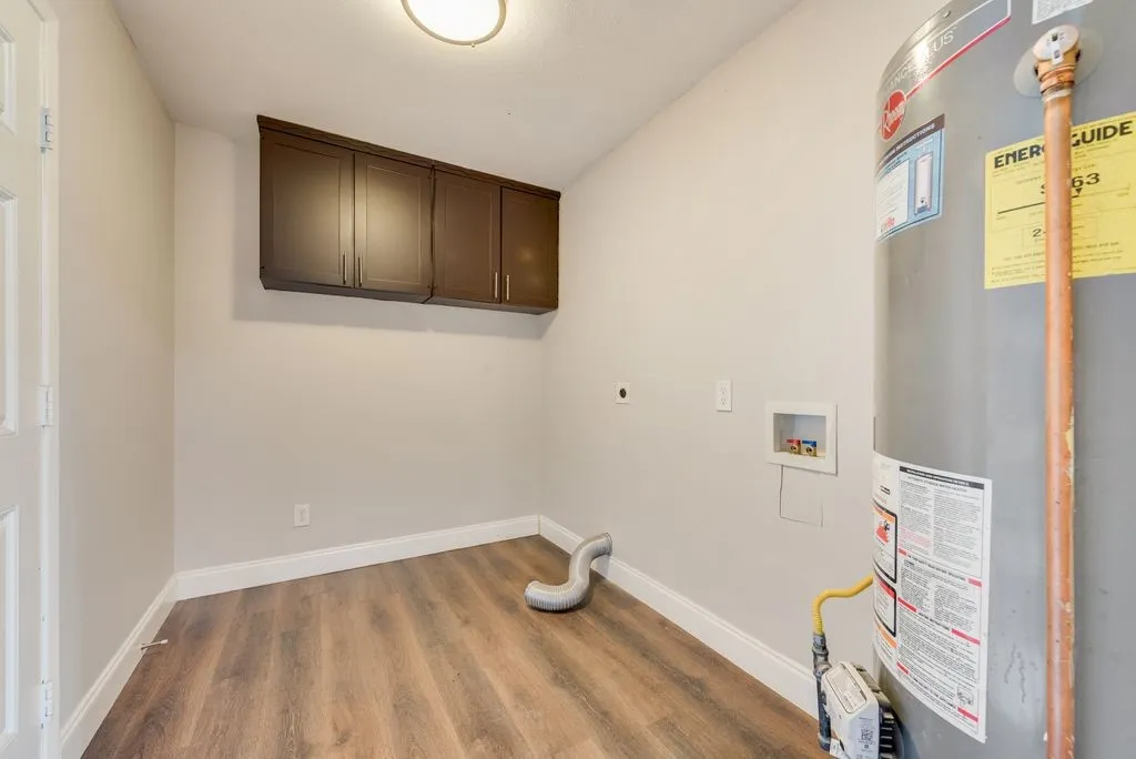 Utility room featuring rich espresso cabinetry, wood-finish flooring, recessed ceiling lighting, and practical wall-mounted storage solutions