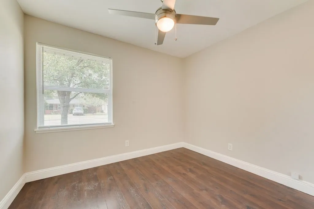 Bedroom featuring wood-finish flooring, neutral wall tones, and white trim