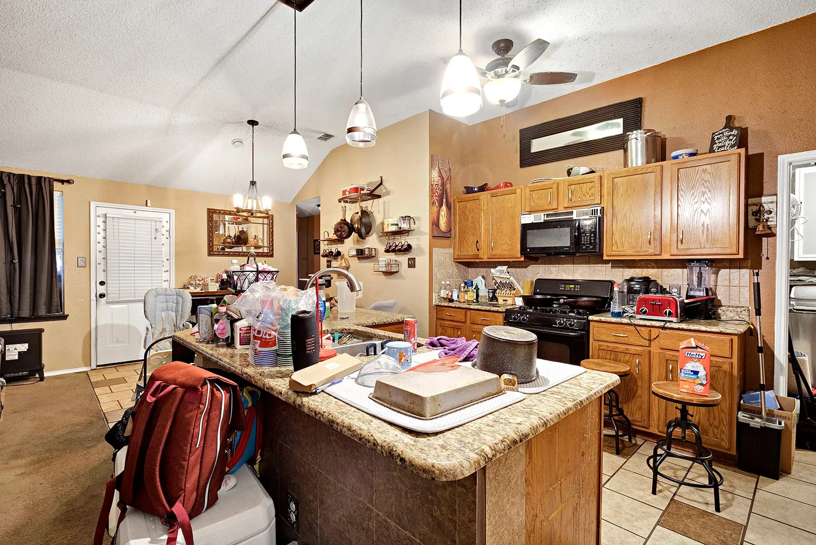 Kitchen featuring wood cabinetry, granite-look countertops, and tile flooring