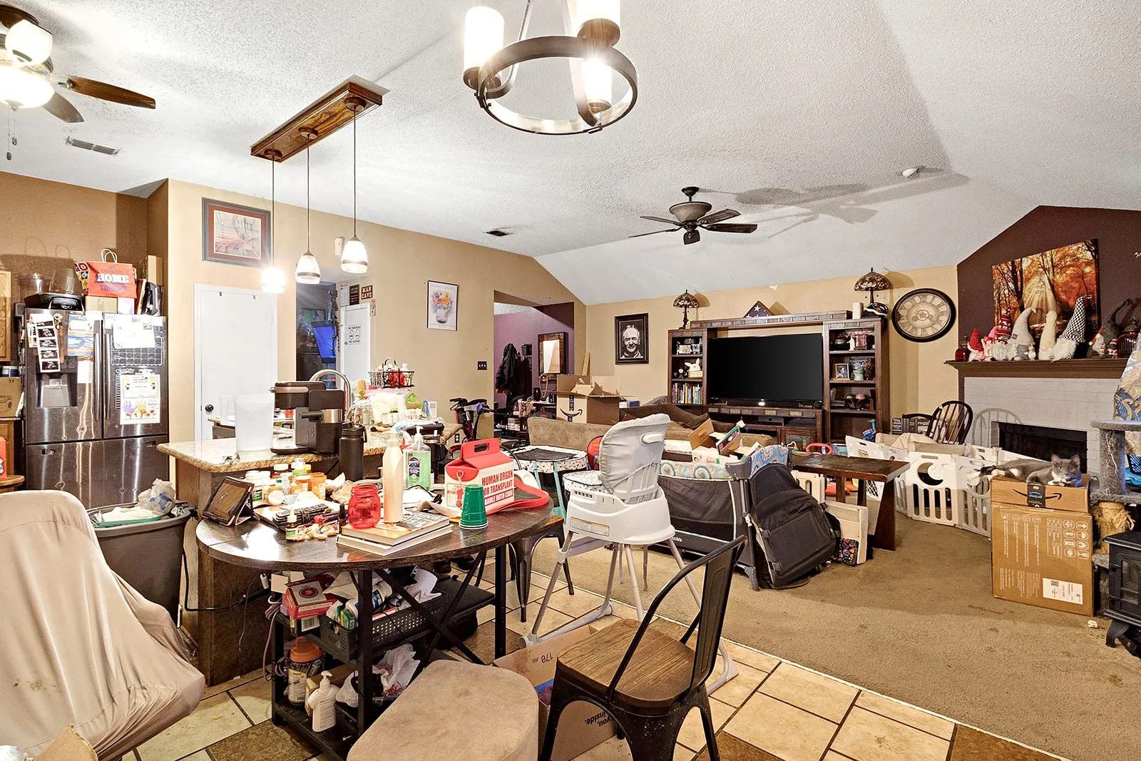 Spacious living area featuring vaulted ceilings, a fireplace with mantel, and recessed shelving