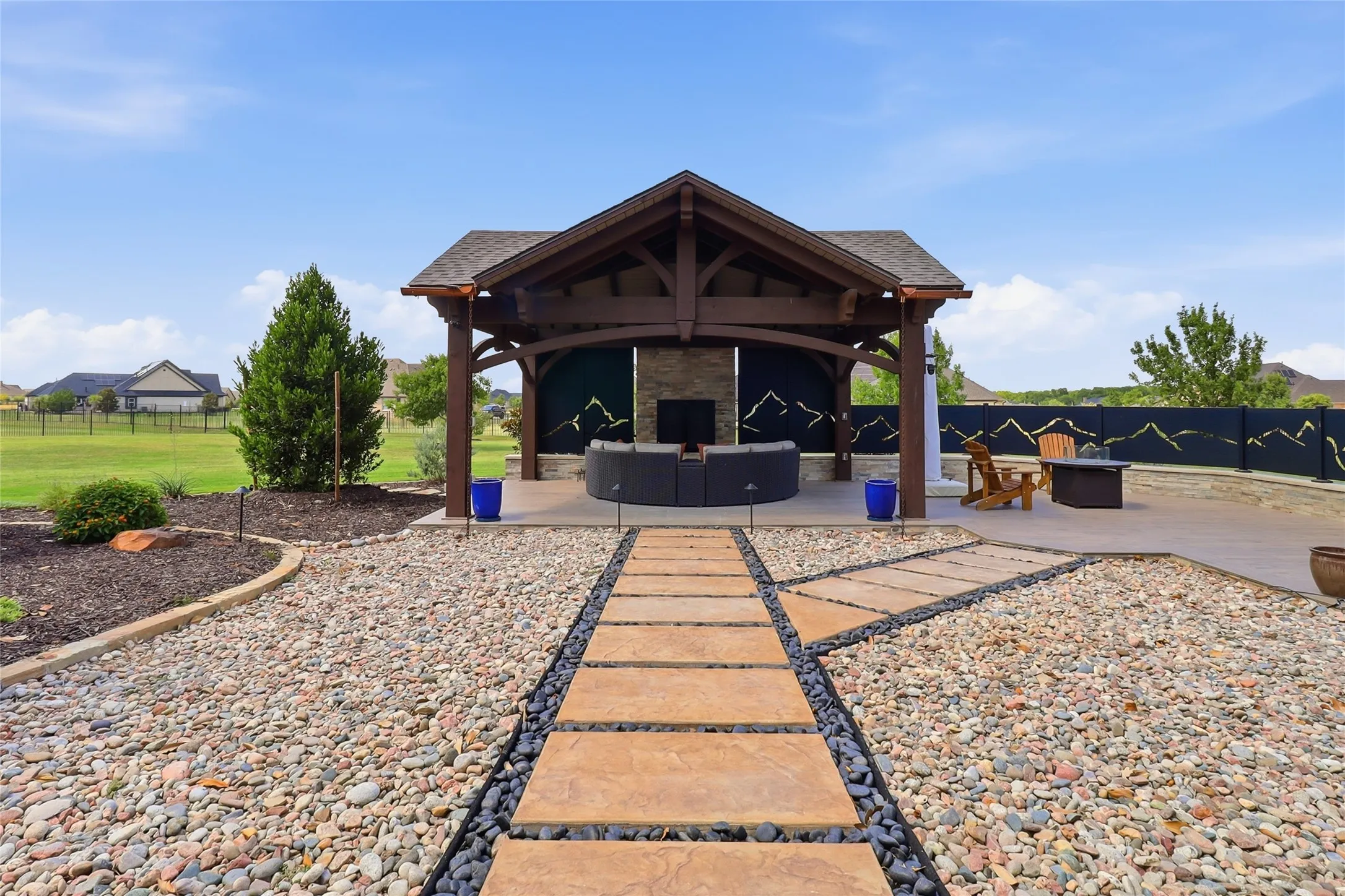 Expansive pavilion is ideal for expanded entertaining or outdoor activities with its floor-to-ceiling fireplace and custom fencing for privacy.  A true oasis!