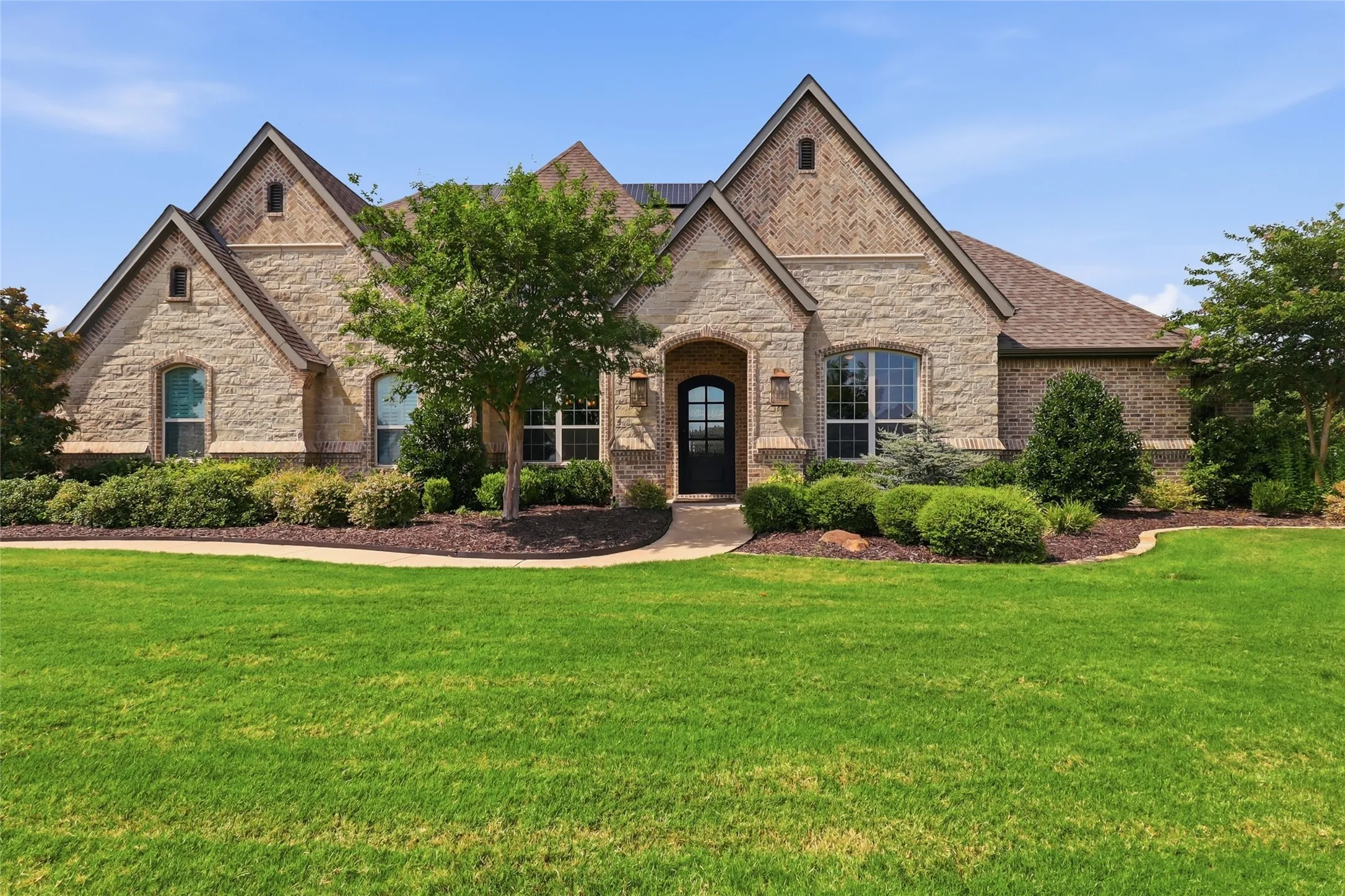 Beautiful blend of stone and brick exterior and manicured grounds.