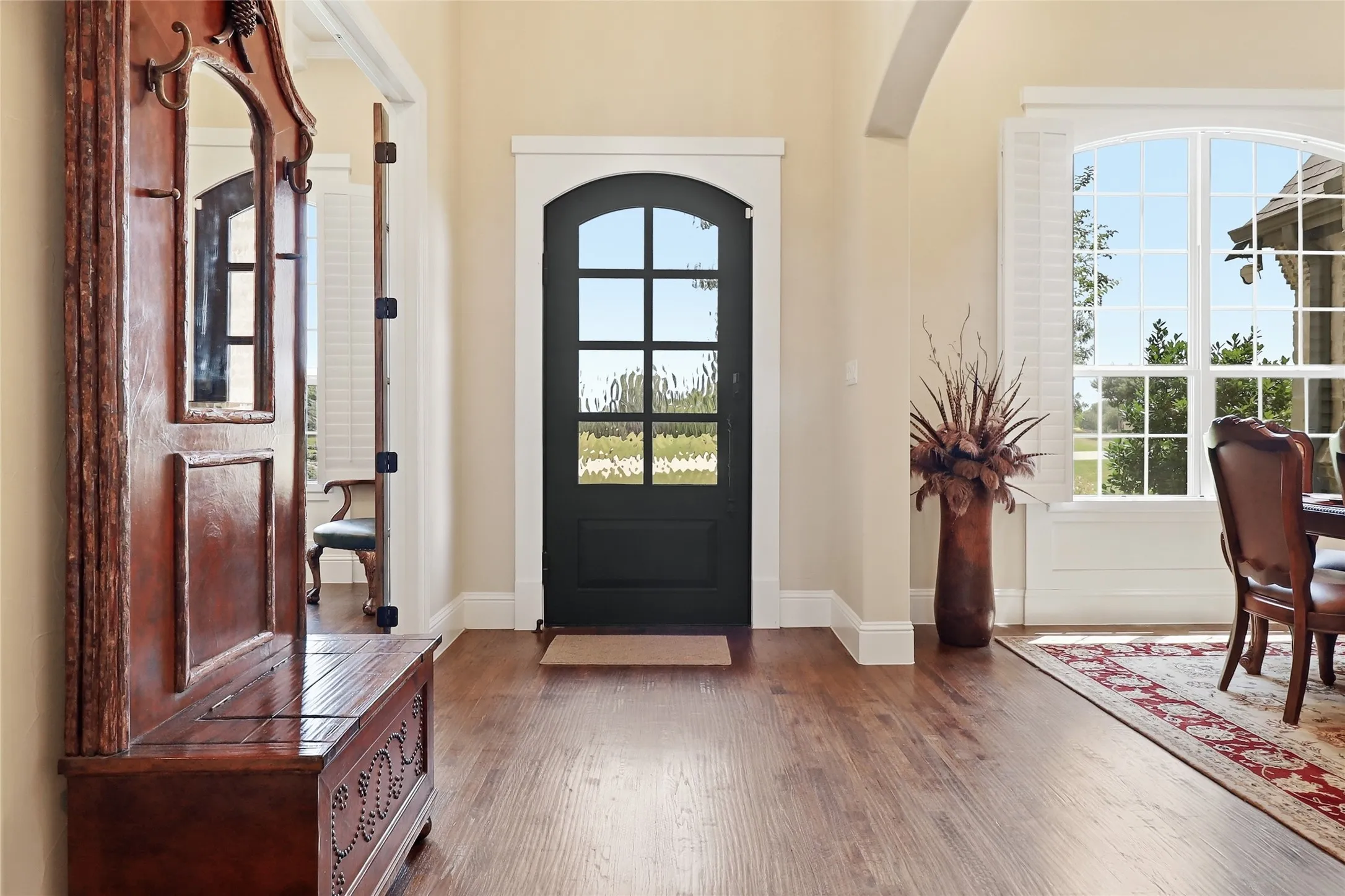 Welcome home through the iron custom-designed arched front door and elegant wood flooring.