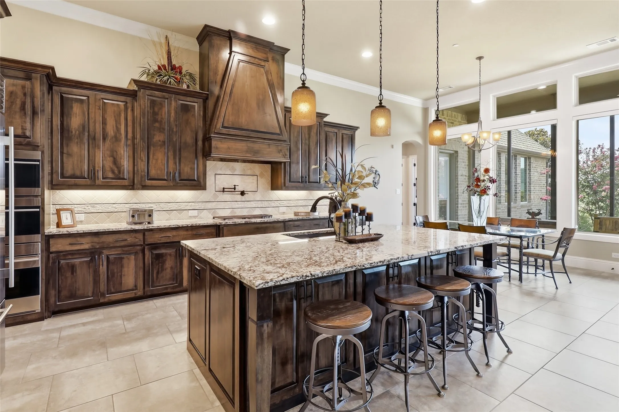 Entertaining is a pleasure with this expansive island and beautifully-crafted maple cabinets.  Notice the pot-filler fixture above the 5-burner gas cooktop.  Each of the lower cabinets has custom-pull-out drawers.