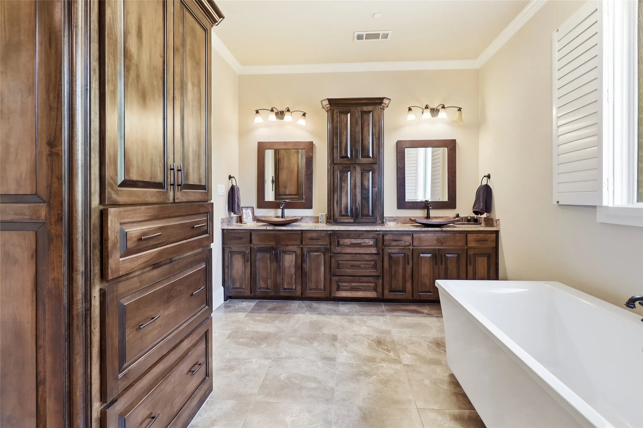 Primary bathroom offers custom double hammered copper sinks, mirrors, oversized soaking tub, steam shower, and abundant built-in cabinet storage space.