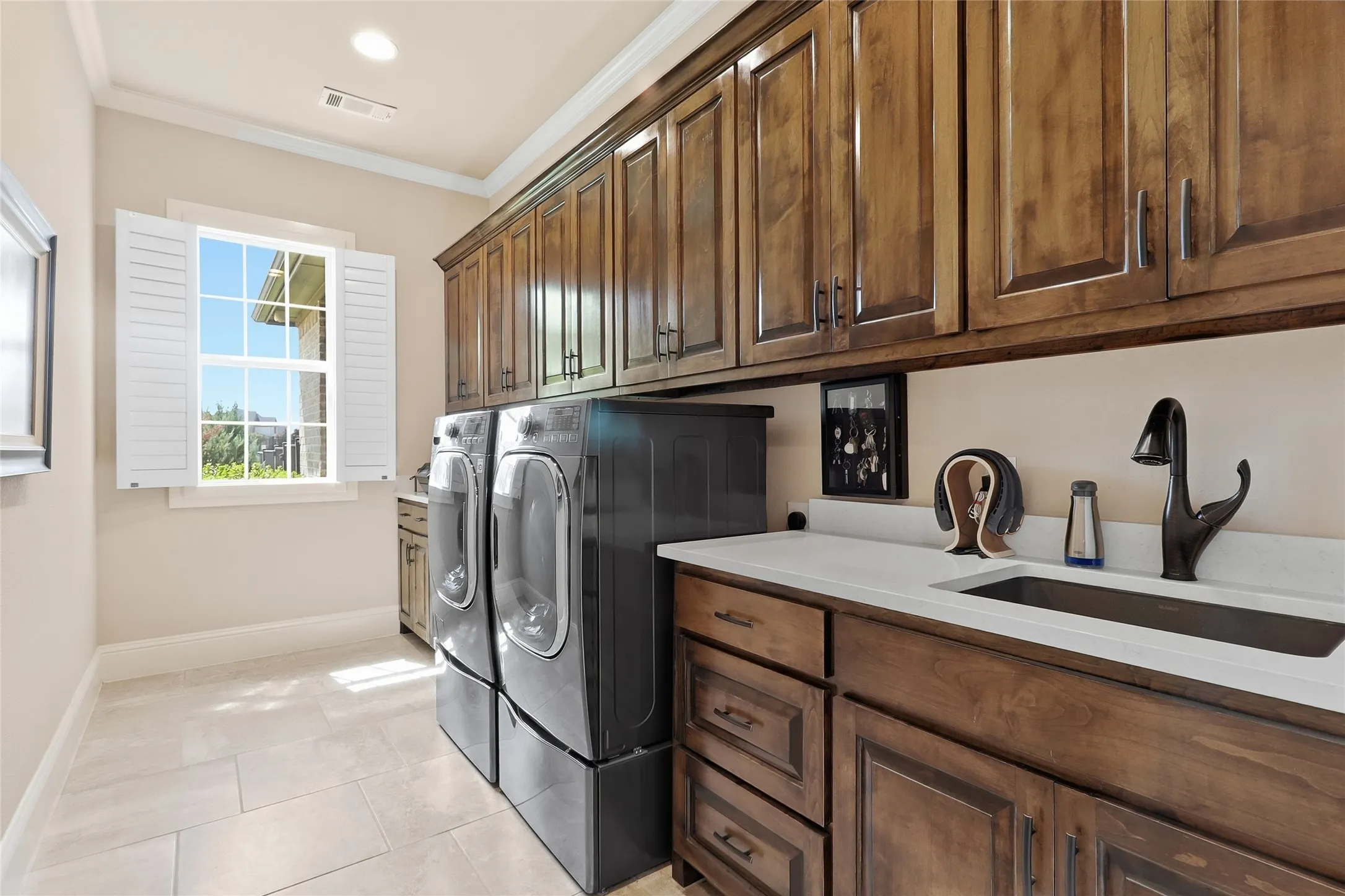 Truly an oversized utility room with its "touch-free" faucet, abundant storage custom cabinets, and folding counter.