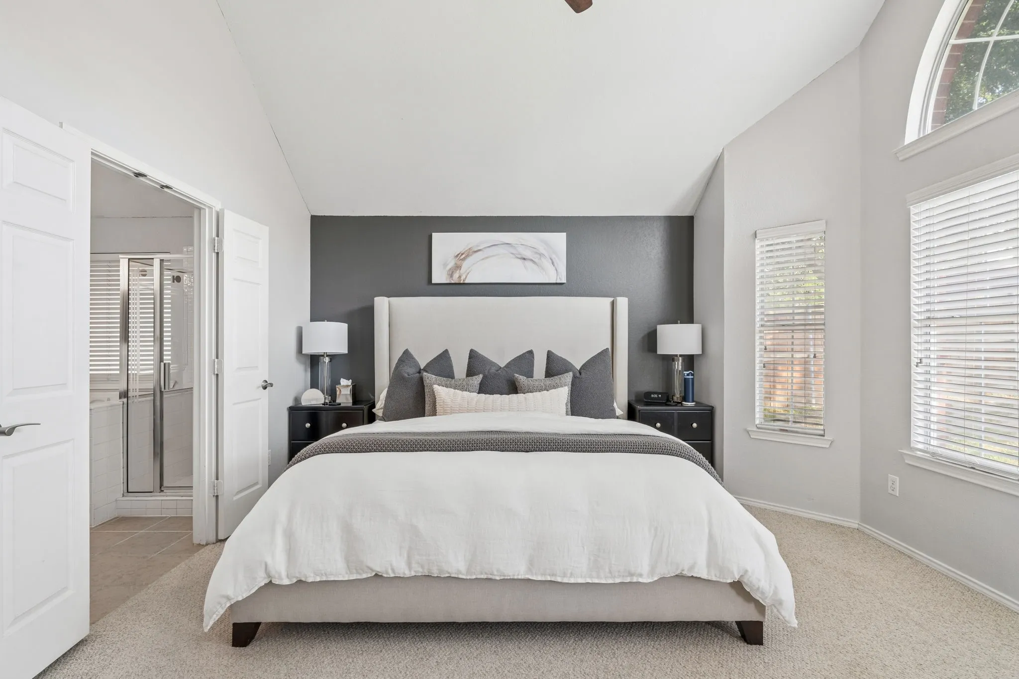 Primary bedroom with vaulted ceiling.