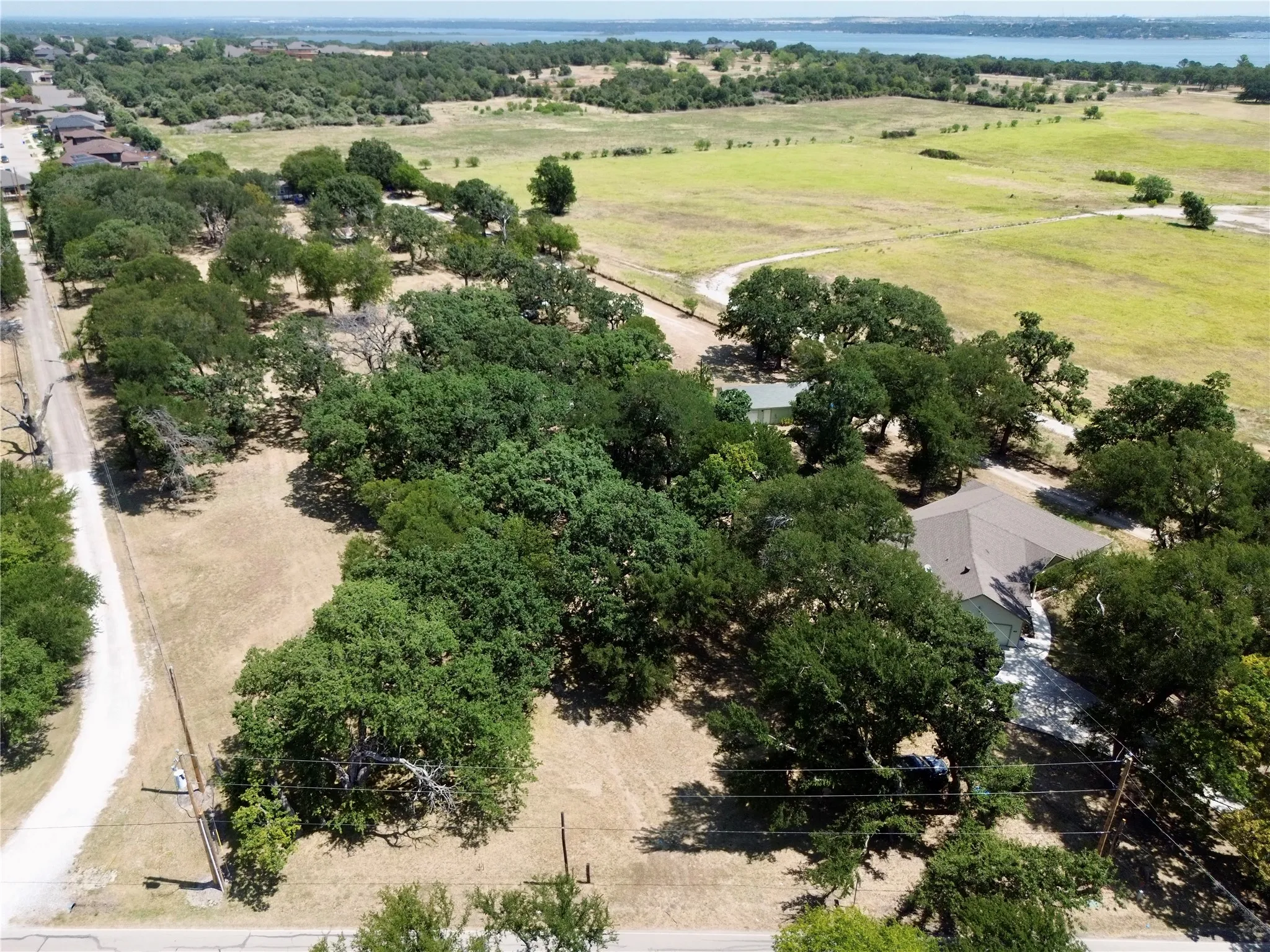Expansive property featuring mature trees and a gravel road frontage