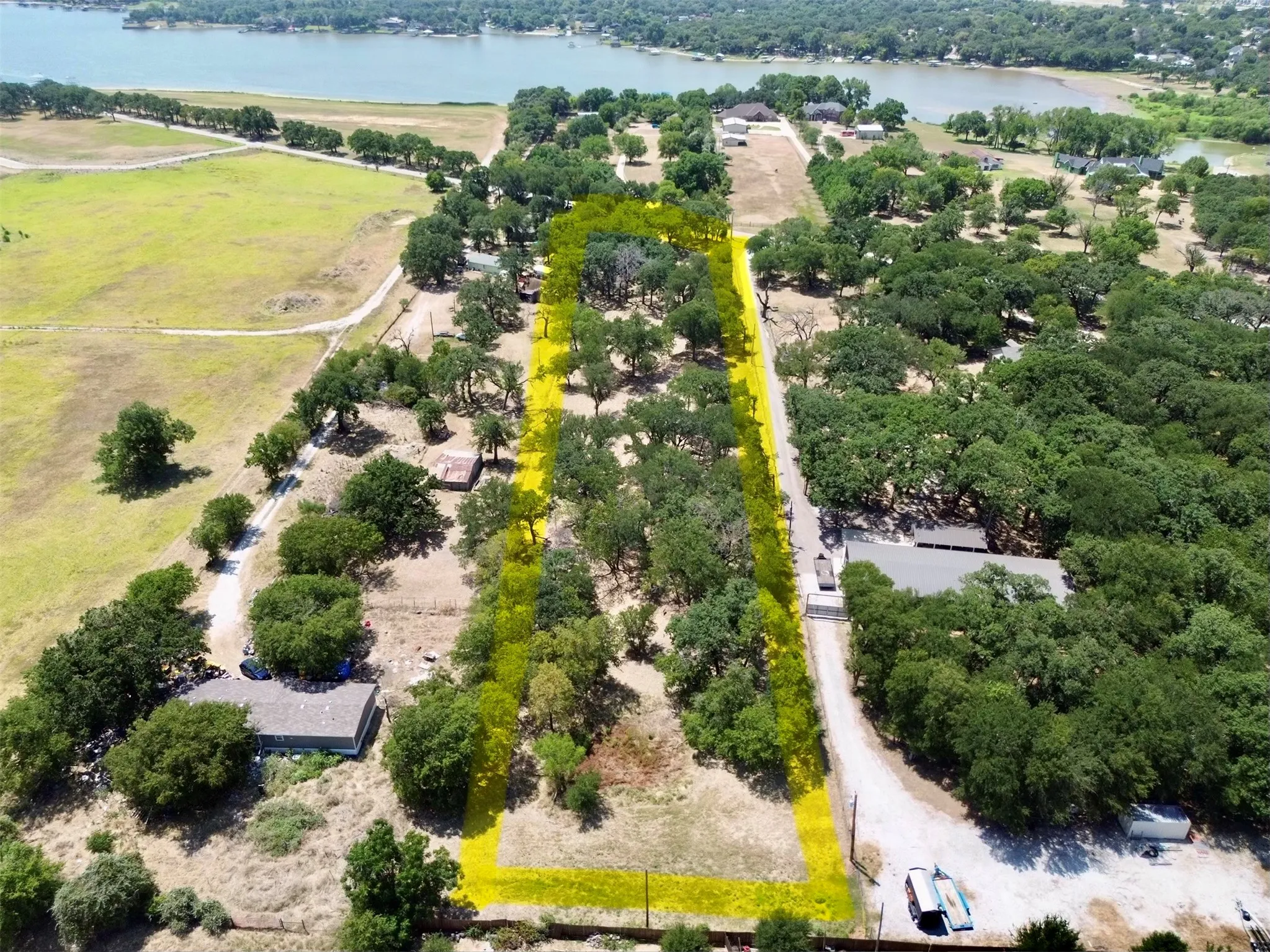 Expansive treed lot featuring a waterfront backdrop and established natural landscaping