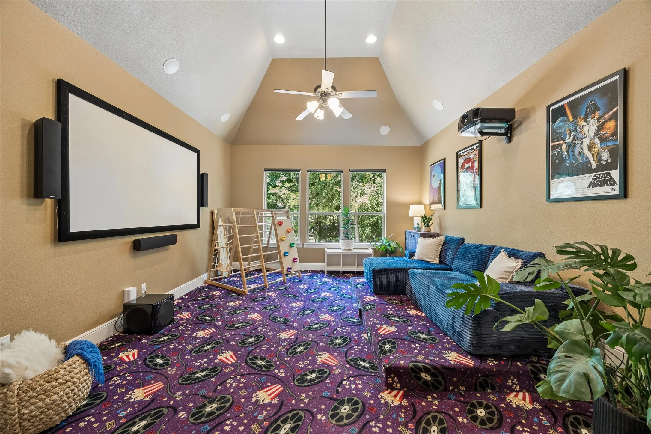 Media room featuring a vaulted ceiling with a ceiling fan, recessed lighting, and a large projection screen with integrated speakers