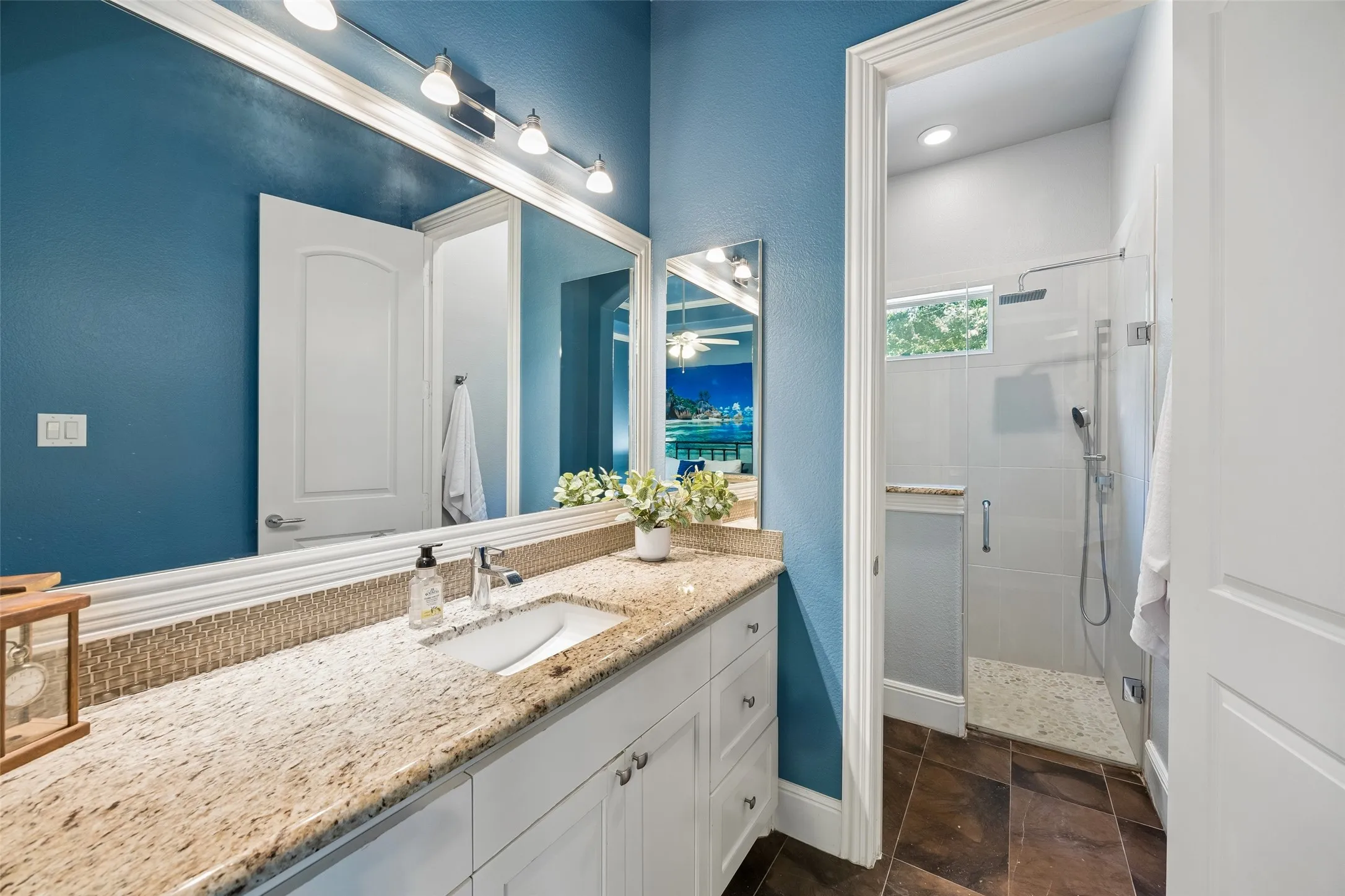 Bathroom vanity featuring a single undermount sink, granite countertop, and white cabinetry